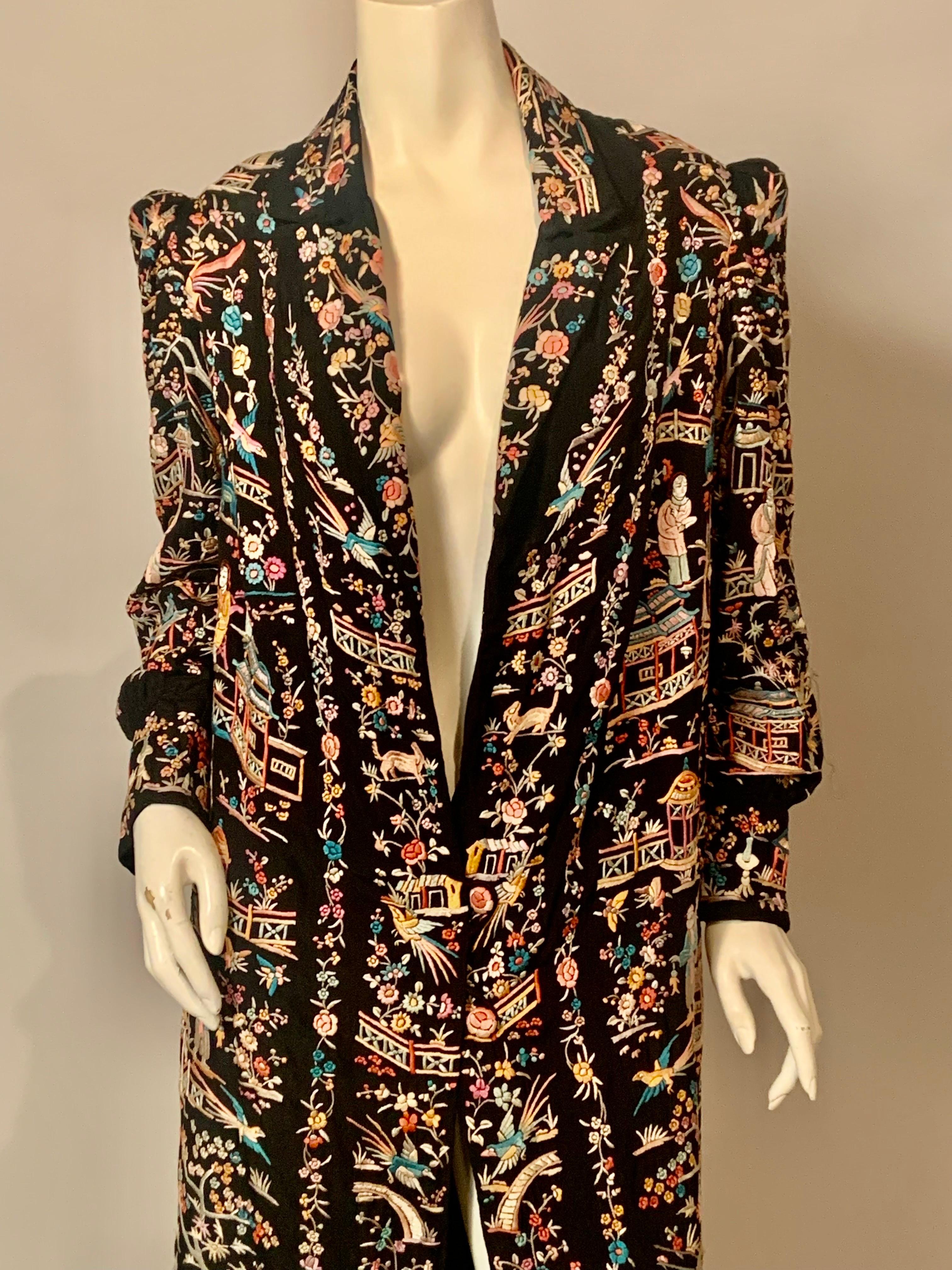 One of the best Chinese embroidered coats I have ever offered for sale, this black silk coat is smothered with gorgeous and colorful hand embroidery.   Motifs include men and women, birds and animals, pagodas, bridges and walkways and flowers and
