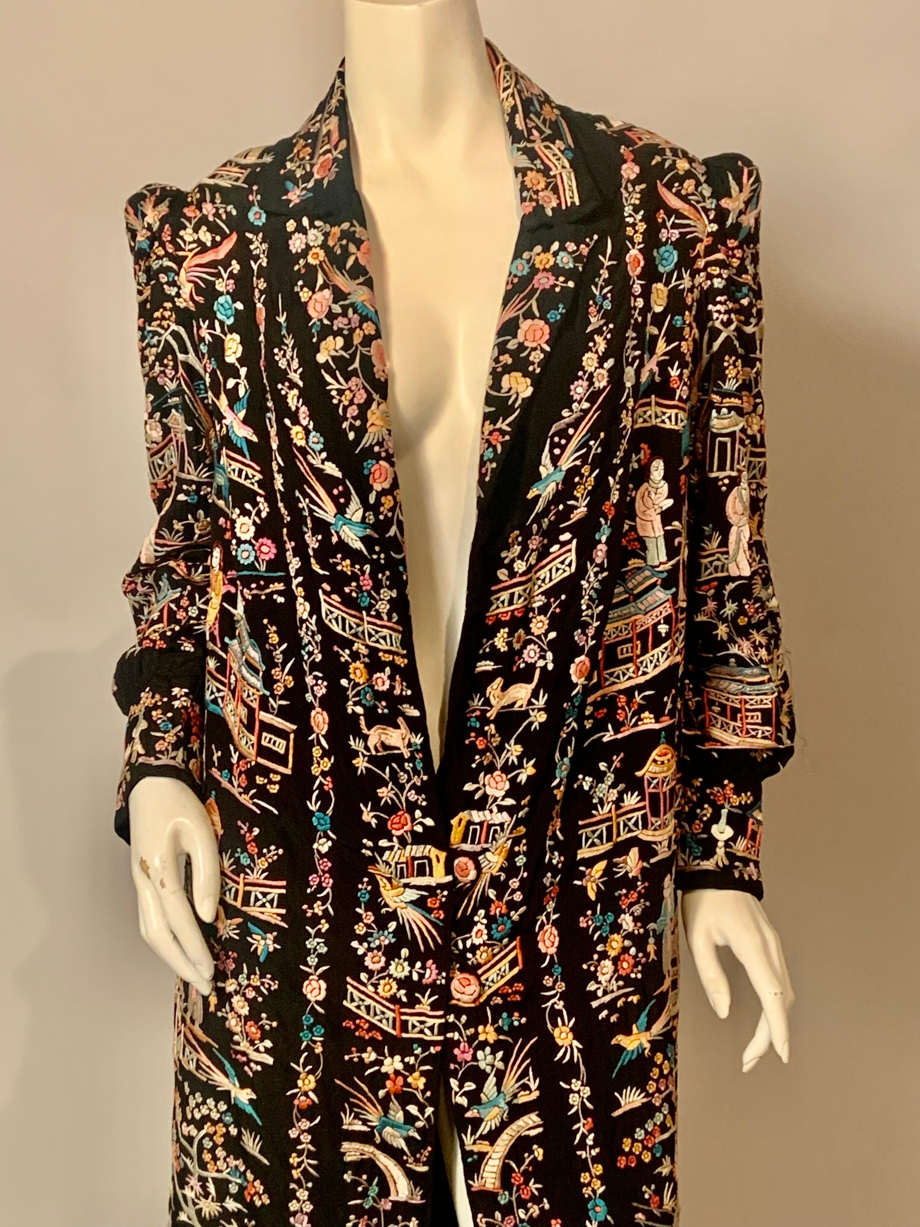 Uno dei migliori cappotti cinesi ricamati che abbia mai messo in vendita, questo cappotto di seta nera è ricoperto da splendidi e colorati ricami a mano.   I motivi includono uomini e donne, uccelli e animali, pagode, ponti e passerelle, fiori e