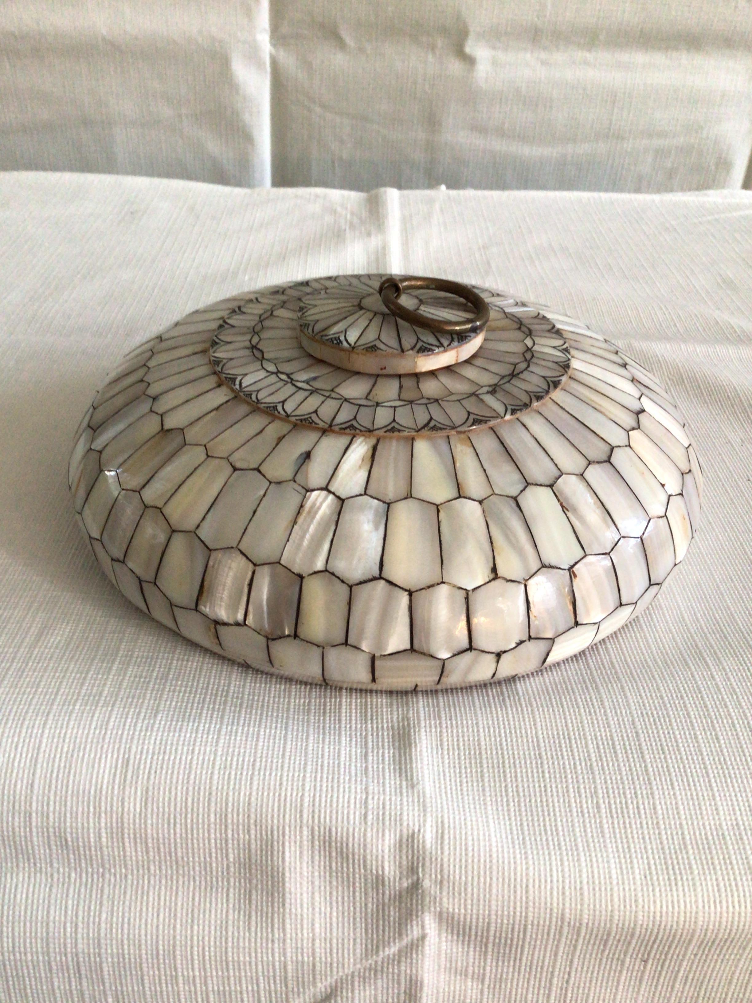 1920s circular mother of pearl box with removable lid. Mother of pearl tiles are hand applied to this solid circular wooden lidded box.