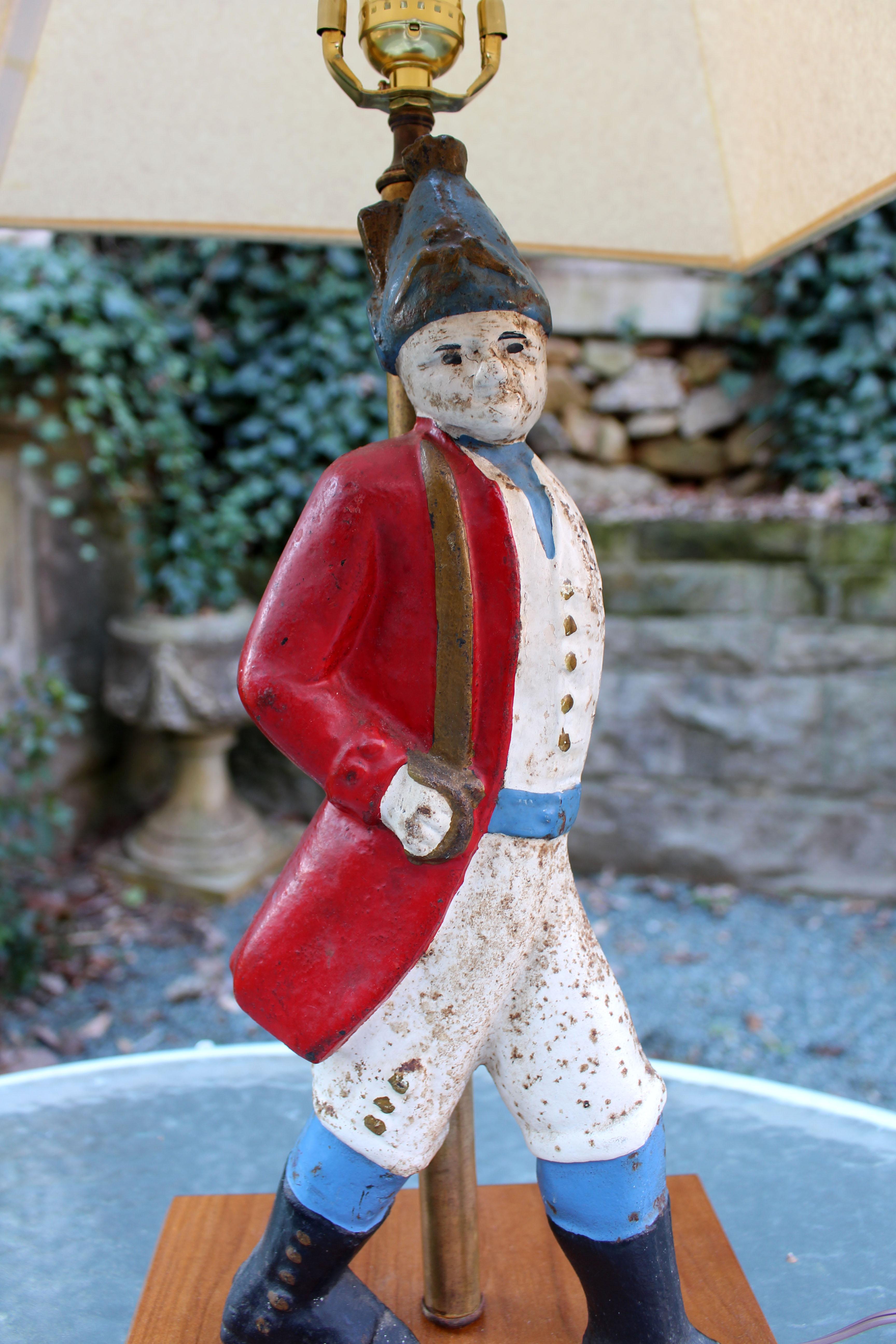 Colonial revival Hessian soldier andiron now mounted as a lamp, c.1920. Colorfully enameled. Some rust and wear. Newly wired with solid cherry base. Overall: 31