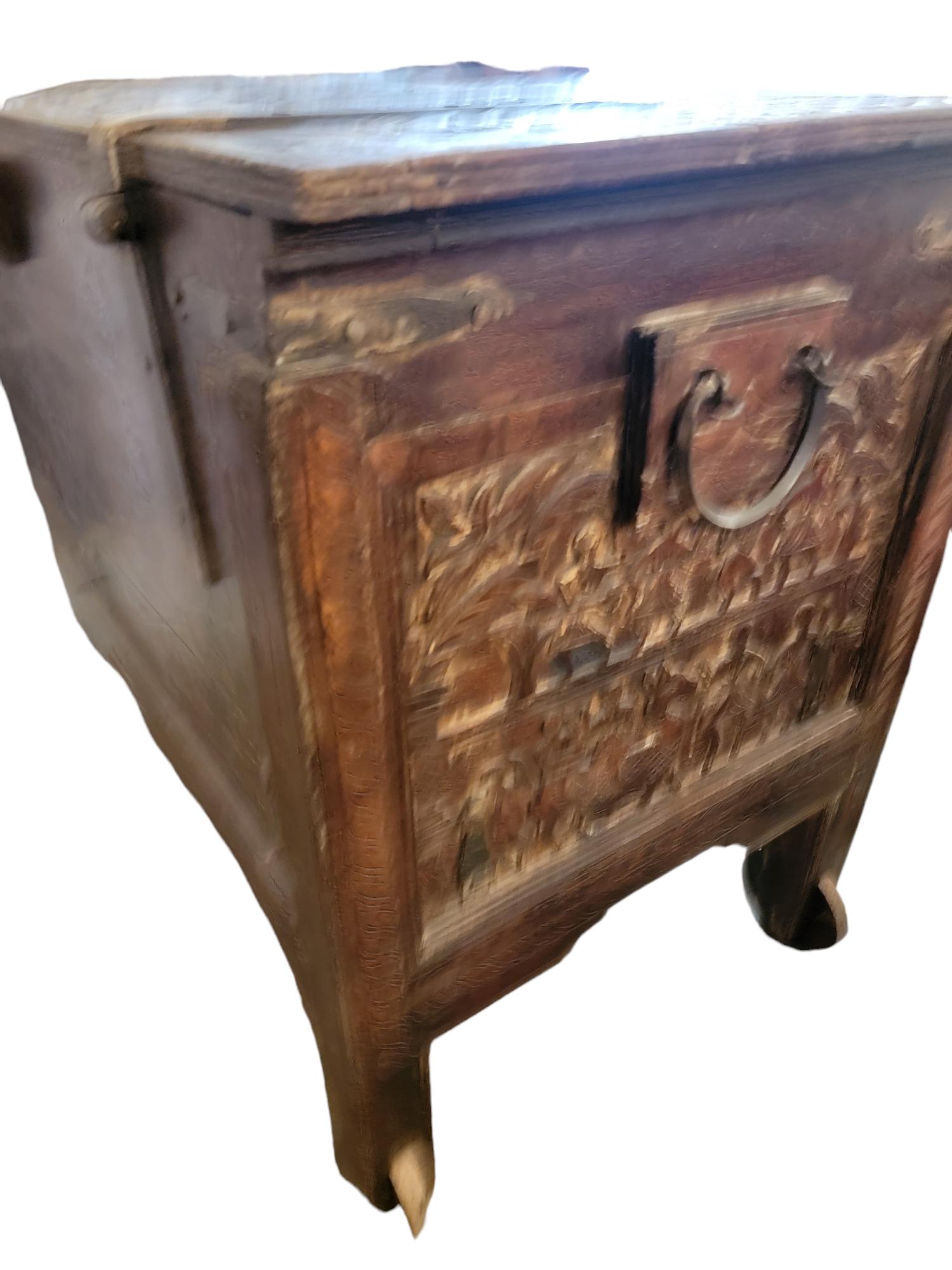 1920s Continental Wooden Chest With Wooden Rollers. Beautiful design with figural carvings on the exterior of the trunk. Iron fitting and hinges provide a strong connection and decorative look to this trunk. Wonderful patina and age. Some minor