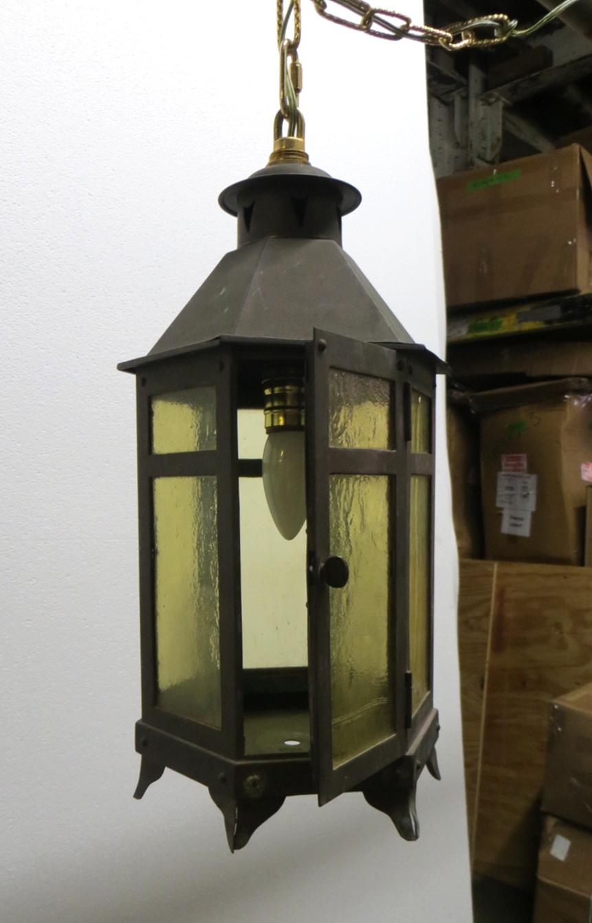 1920s Arts & Crafts style copper lantern with amber colored glass and a single bulb. This can be seen at our 400 Gilligan St location in Scranton, PA.