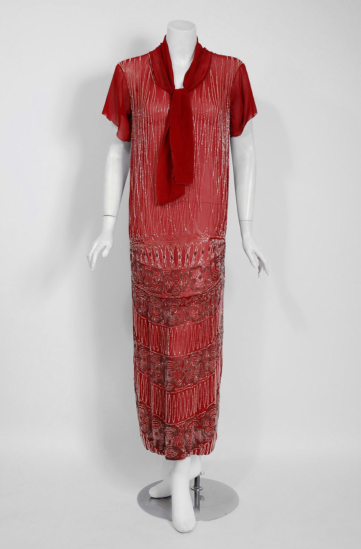 Vibrant flapper dresses from the early 20th century are perennial favorites and this one is a show-stopper! The garment's simple unstructured style is so modern; the fine deco floral beadwork is a treasure trove of needle art. This beauty, fashioned