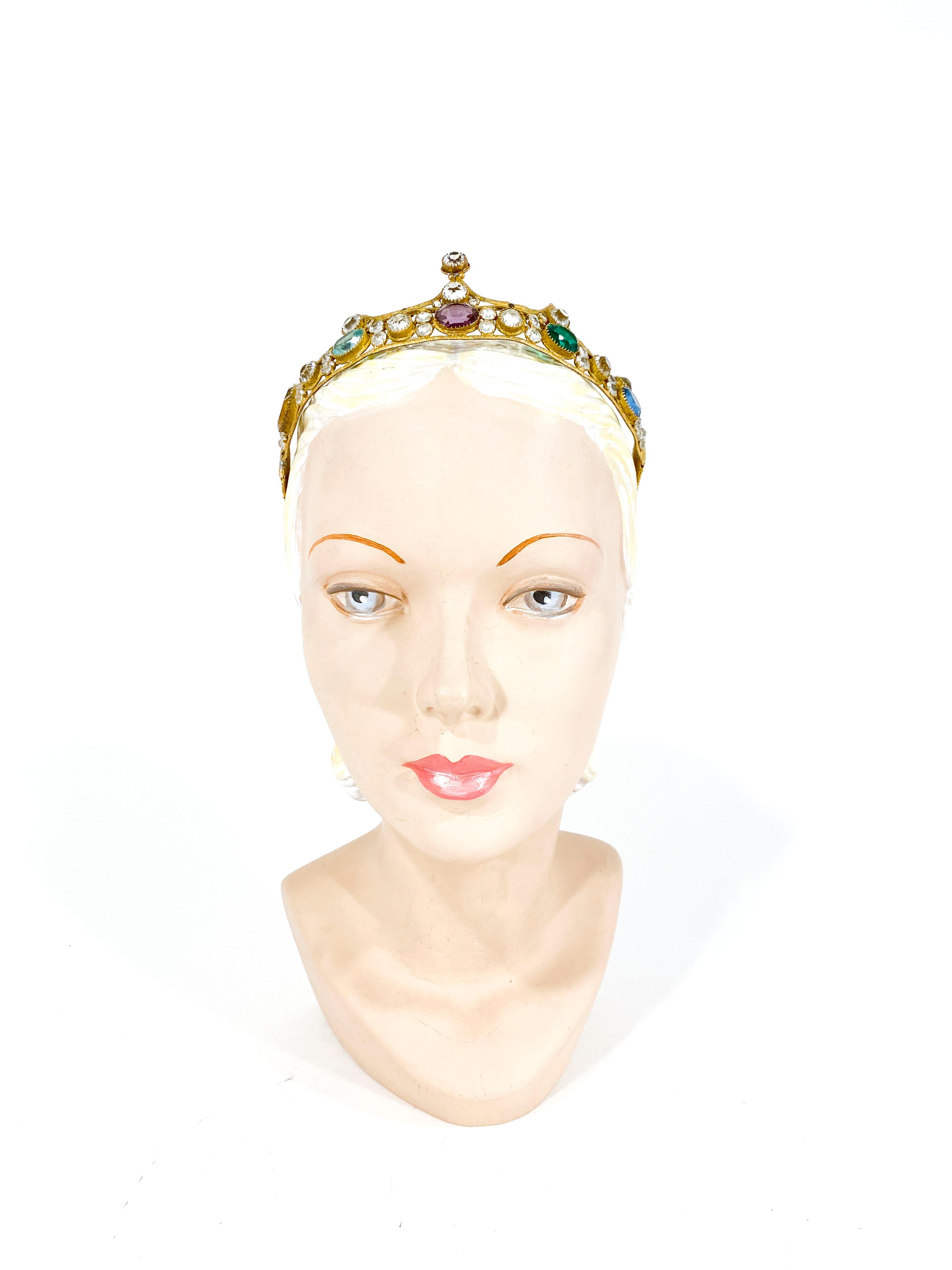 1920s brass tiara with origin multi-colored Czech glass crystals. The crystals are brilliant and and larger ones are colored in gold, aqua, lavender, green, and light blue. The security band has been replaced with a gold band and elastic for comfort
