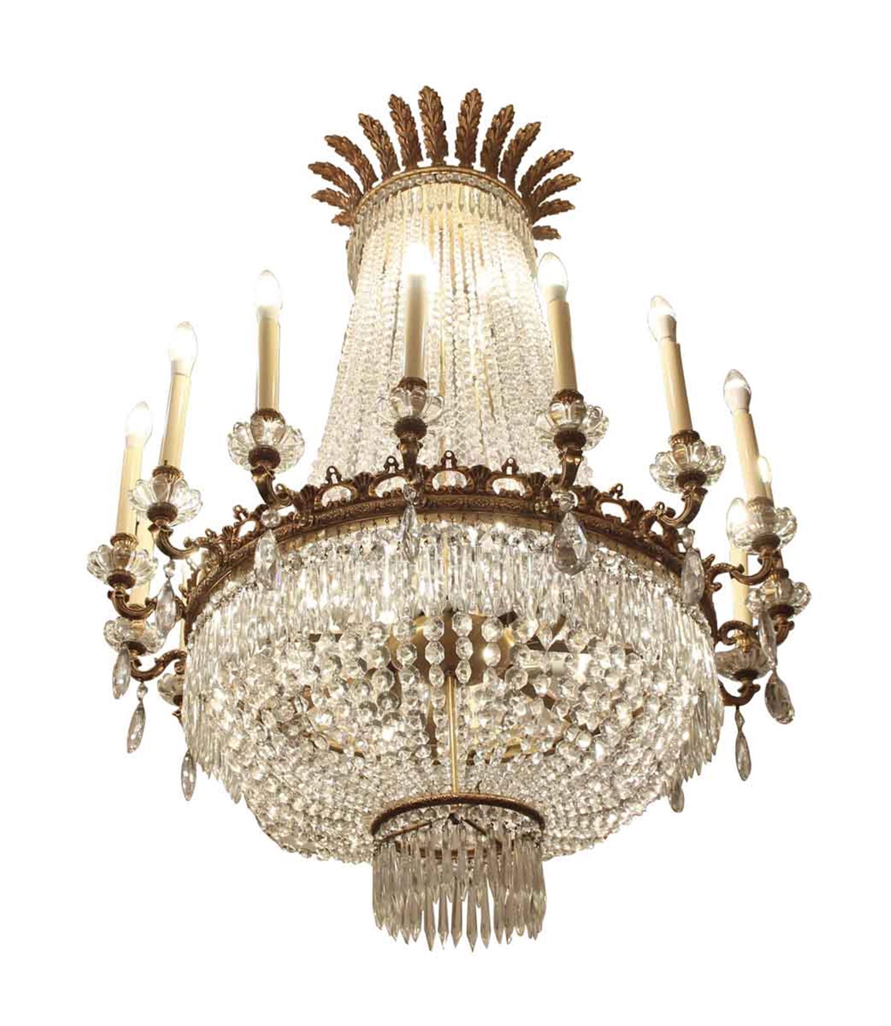 Originally from the 1920s Palace Hotel in NYC, this wonderful large gilt bronze and crystal beaded chandelier has been completely restored. It has 16 candle lights around the perimeter and 16 lights inside behind the crystal. Done in an Empire