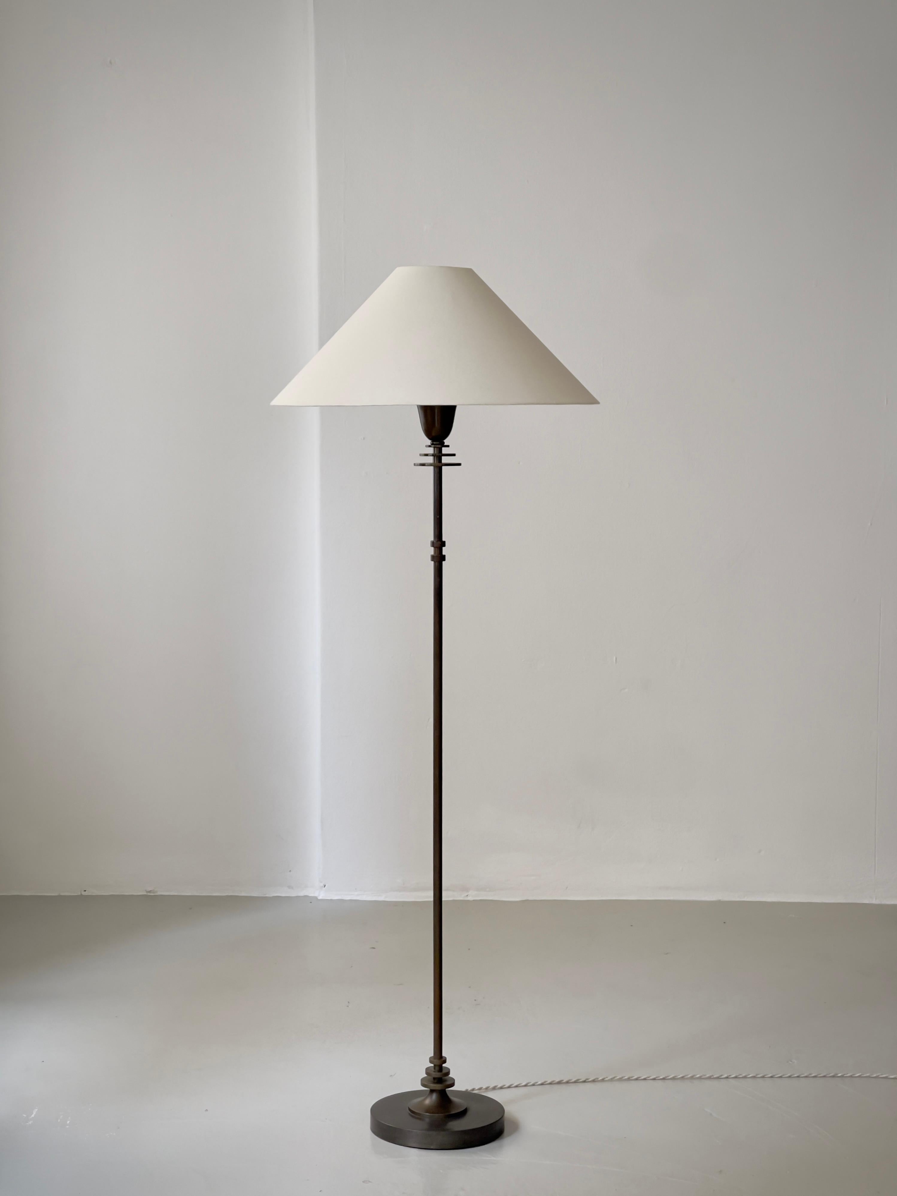This early 20th-century Danish Art Deco floor lamp, masterfully handcrafted in solid patinated bronze, stands as a striking fusion of functional design and sculptural artistry. Created by a skilled Danish blacksmith-sculptor, the lamp reflects the