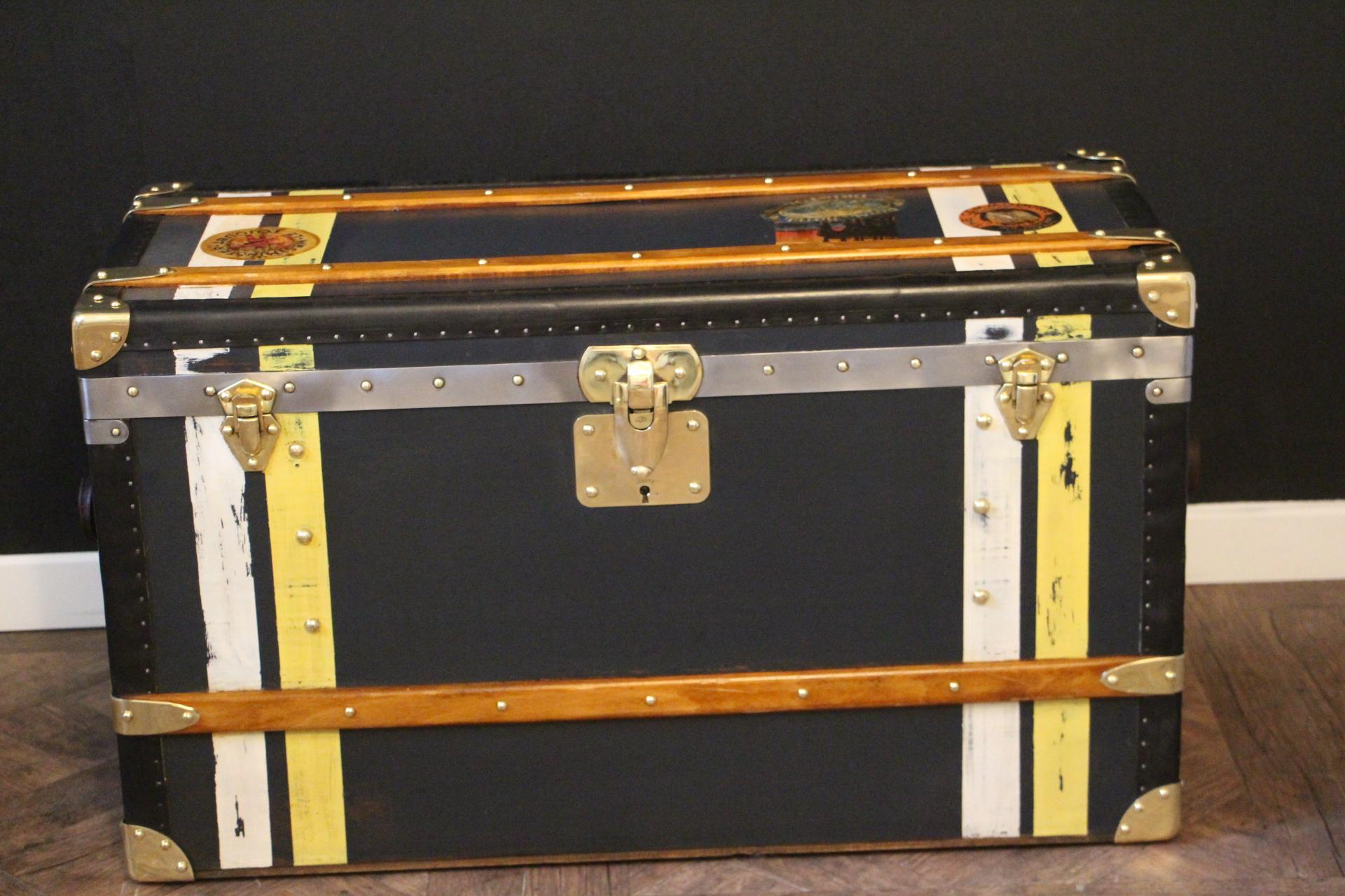 This nice steamer trunk features very unusual dark blue canvas, black lozine trim, large leather side handles and solid brass corners and locks.
Its yellow and white painted stripes of customization add personality to this high quality Moynat