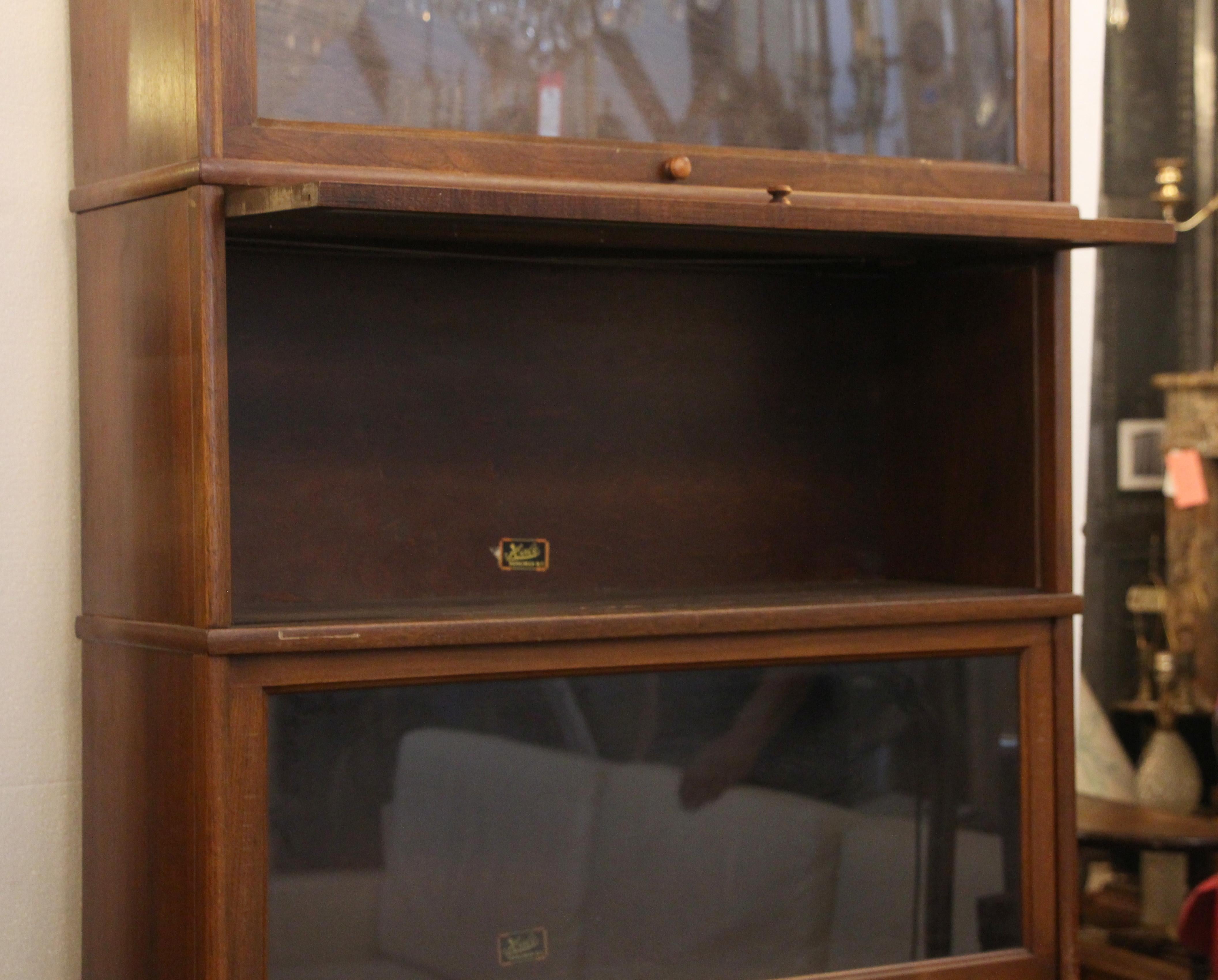 Five-section dark wood tone barrister bookcase with pull out glass doors from the 1920s. Made by Hale. This can be seen at our 2420 Broadway location on the upper west side in Manhattan.