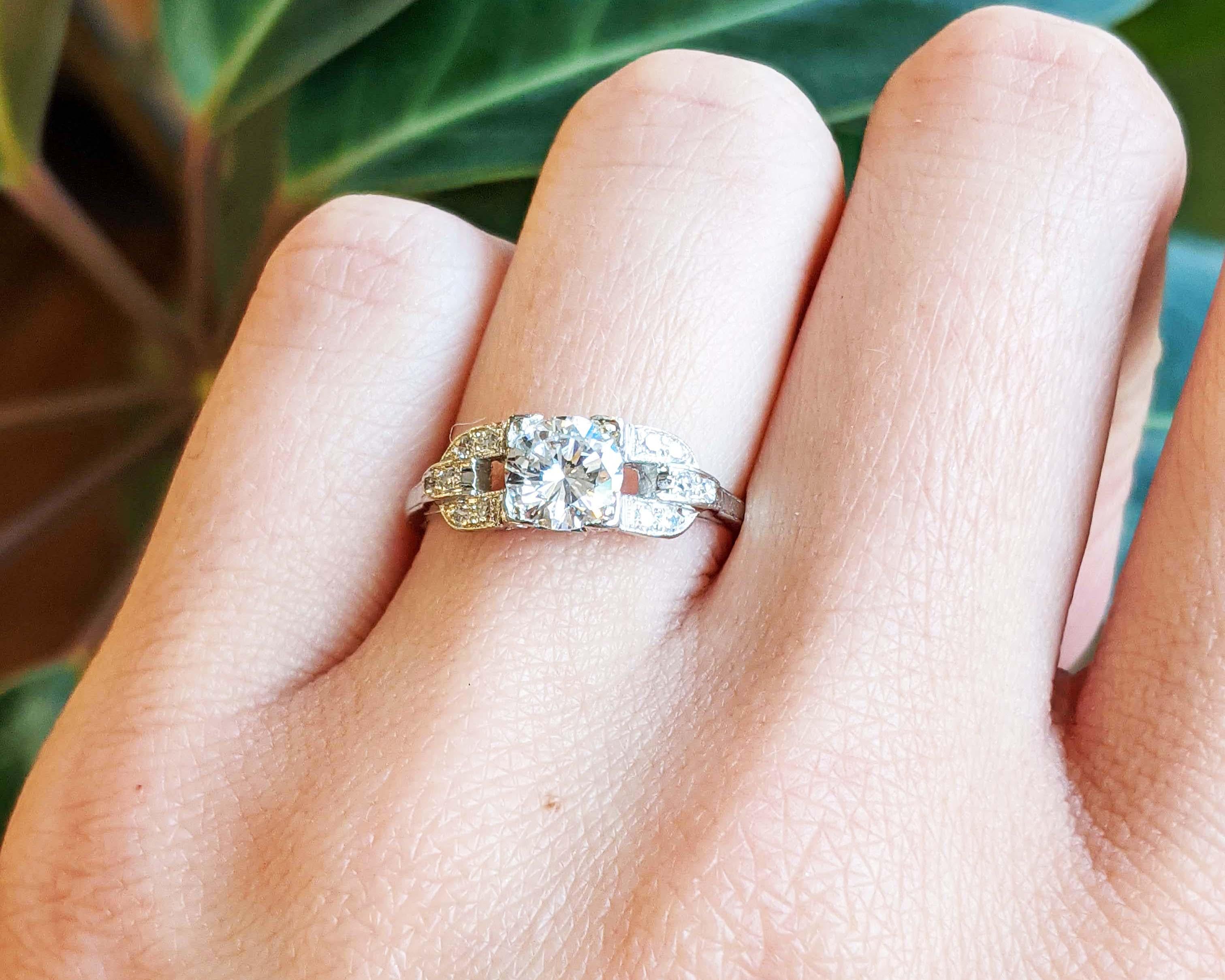 This gorgeous Art Deco engagement ring is in bright white platinum and features a stunning Euro-cut diamond center.
The understated architectural design of the setting is a definitive Deco design featuring a subtle element of negative space and fine
