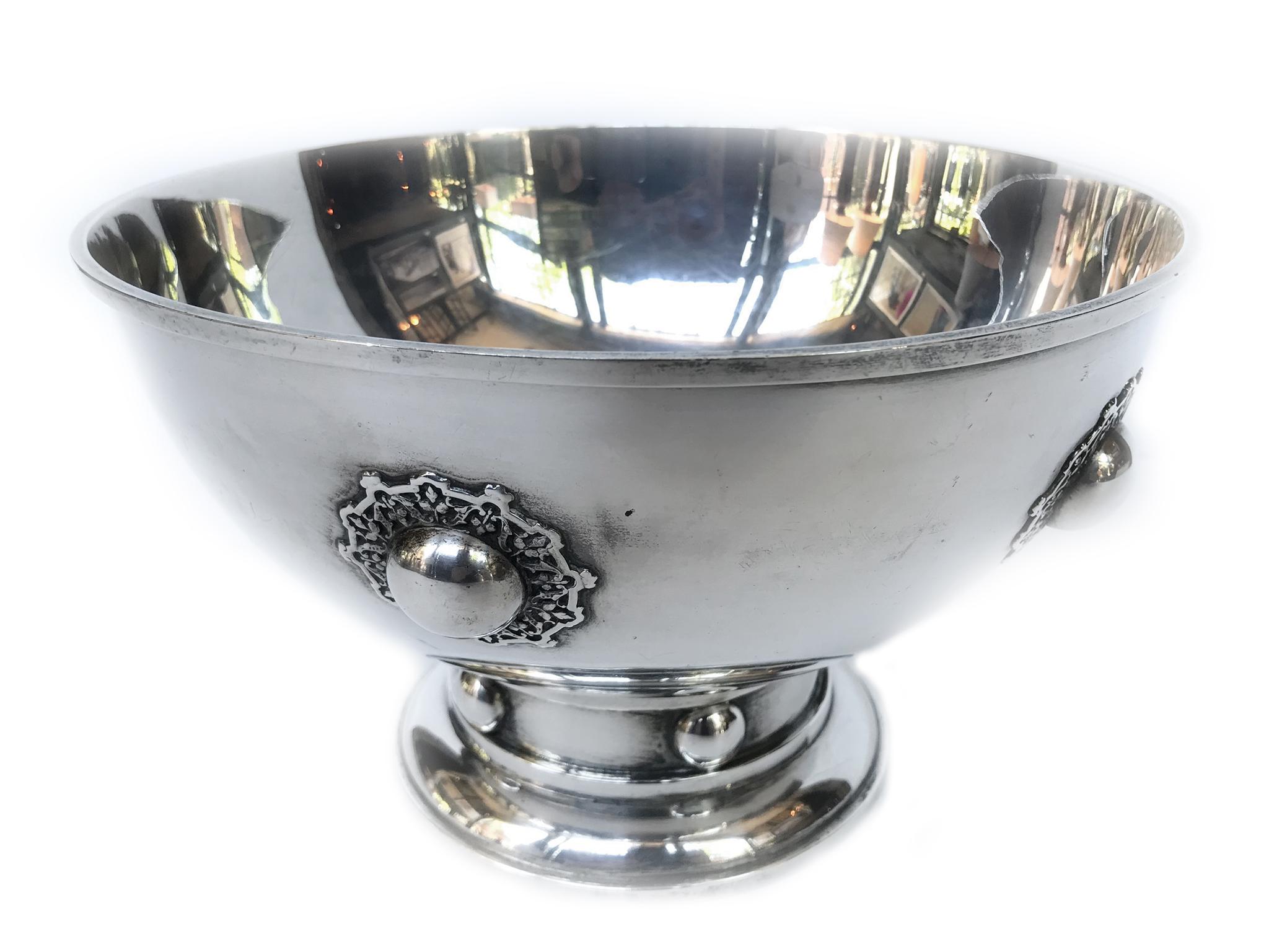 Cuenco de plata de ley de los años 20 diseñado por O.R. Dunn para Hawkes Sterling. Su elegante diseño presenta tachuelas medallón con aureolas florales.

Dimensiones:
9 pulg. de diámetro
5,5 de altura.