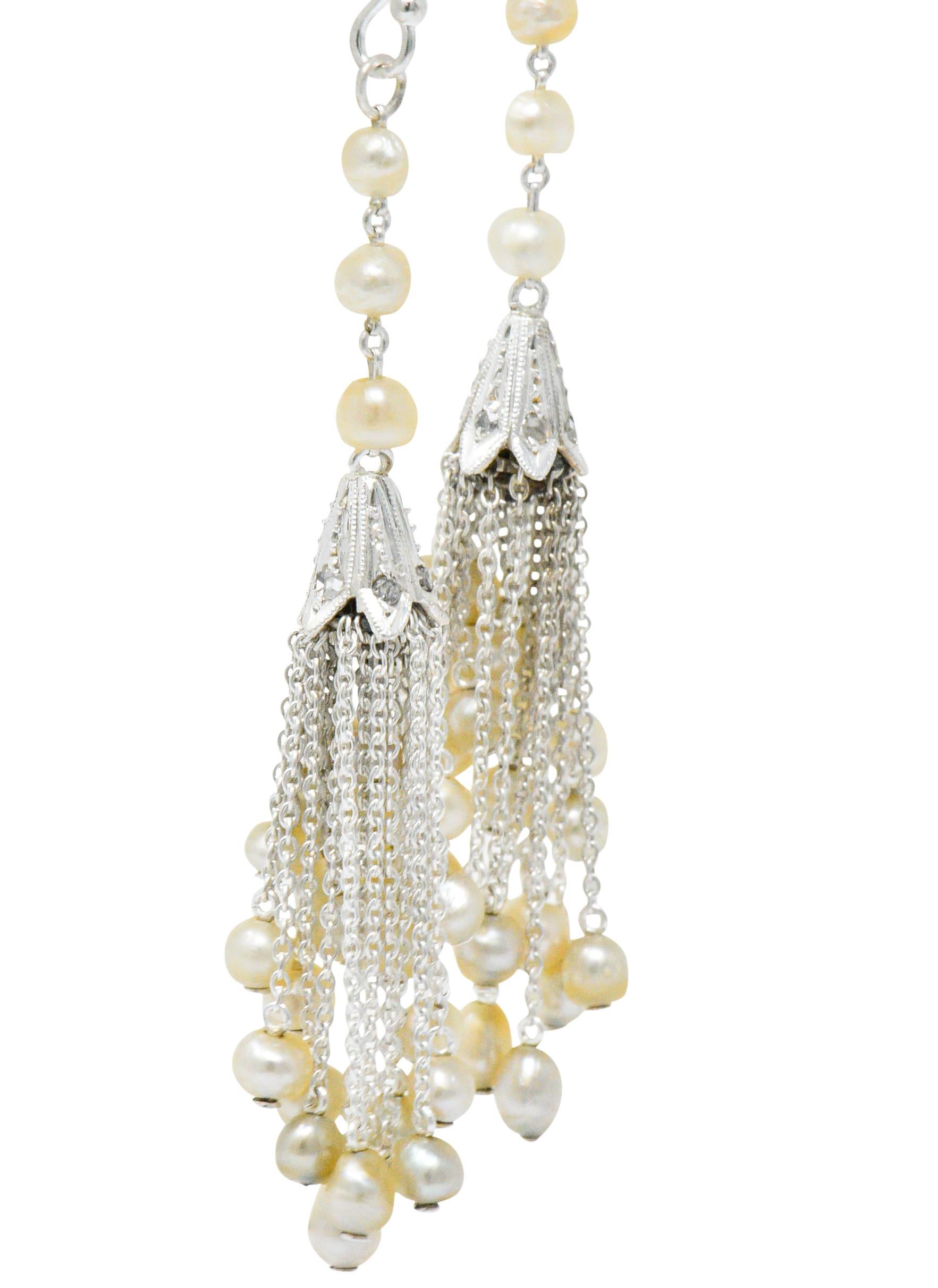 Featuring numerous chain tassels of various lengths terminating in a seed pearl

Descending from a seed pearl chain into a cap set with rose cut diamonds

With 14 karat white gold French hooks

Length: Approx. 2 1/2 Inches

Total Weigh: 6.5