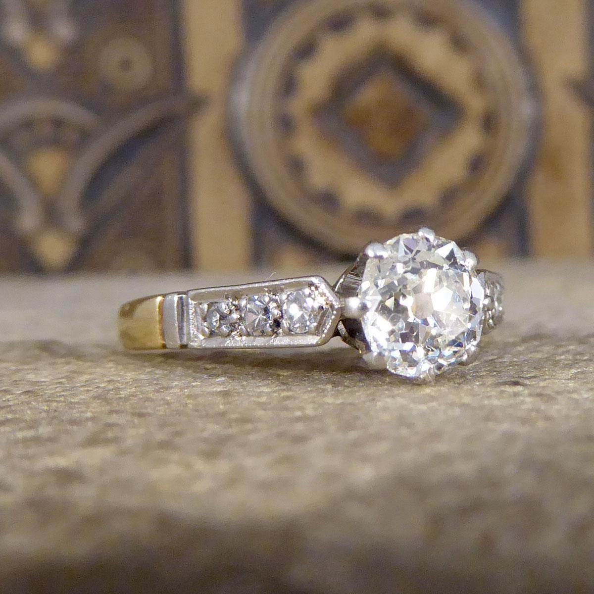 A pretty 18ct Yellow Gold and Platinum ring that was made in the 1920's. This ring features an Old Cushion Cut Diamond in the centre weighing approximately 0.65ct. The centre Diamond has Clarity grading of I with one black inclusion in the stone and