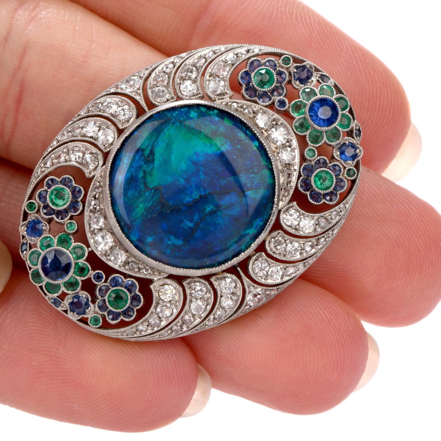 Antique art deco Diamond Opal Sapphire and Emerald Brooch pin inspired in 

a stunning floral motif and crafted in Platinum.

Adorning the center of this magnificent brooach is a round shaped

 Black Opal gem measuring appx. 17.3mm in diameter