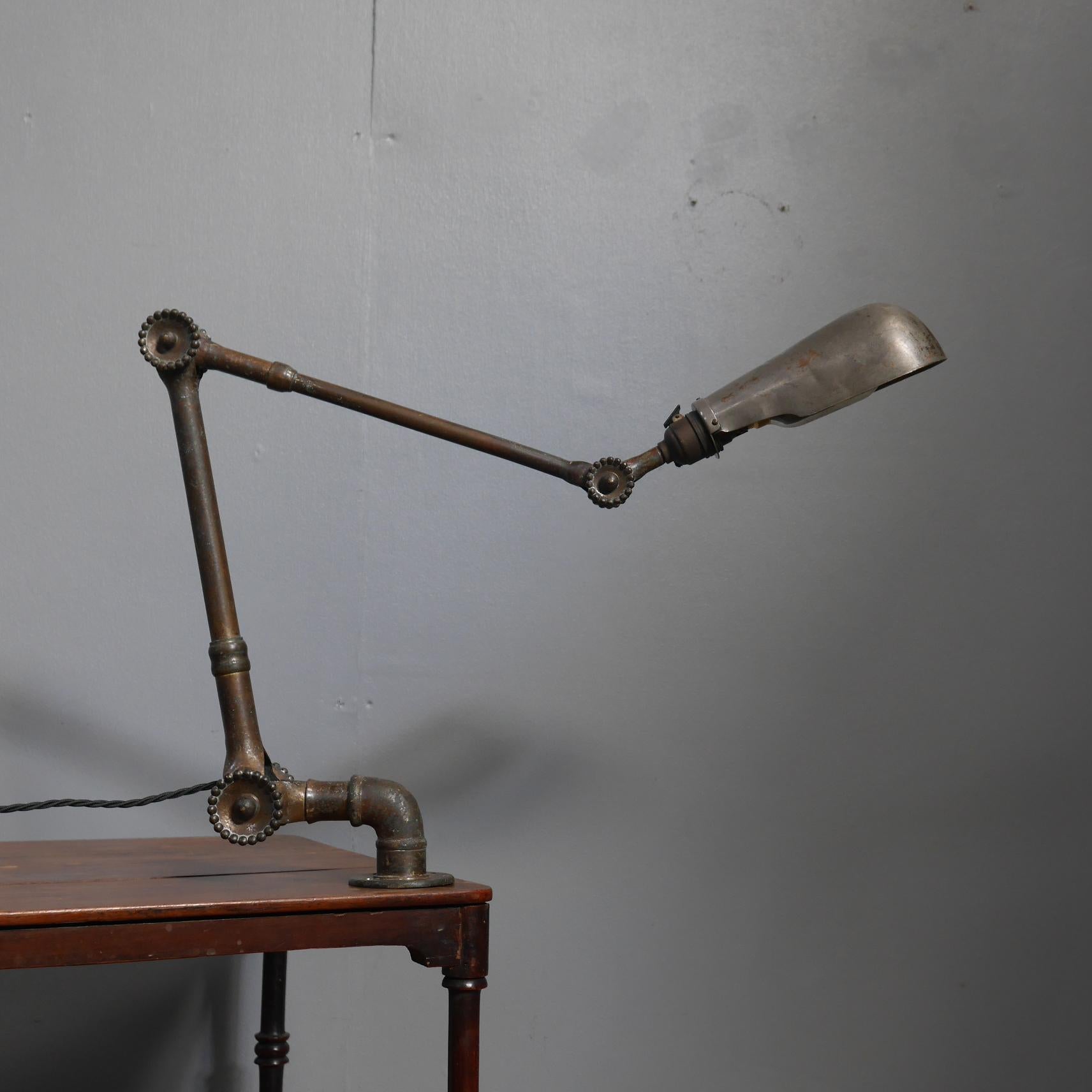 A beautiful early brass wall lamp by Dugdills.
A wonderful articulated wall lamp, in solid brass throughout with the trademark 'daisy head' joints & it's original nickel plated brass shade.
With a phenomenal patina, a superb depth of colour &