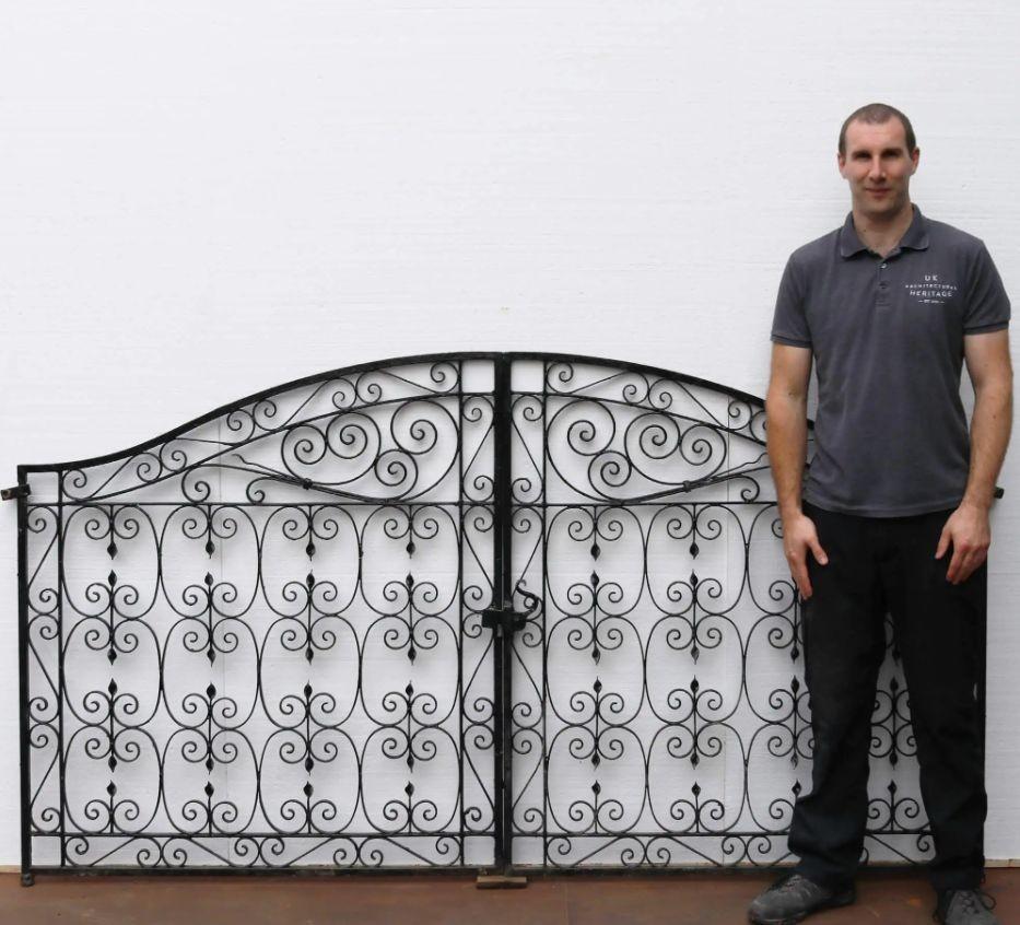 Made in the 1920s, this elegant pair of wrought iron garden gates have stood the test of time. They are exceptionally well maintained, detailed with an abundance of ornate scrollwork, handcrafted by a talented blacksmith 100 years ago. They make a