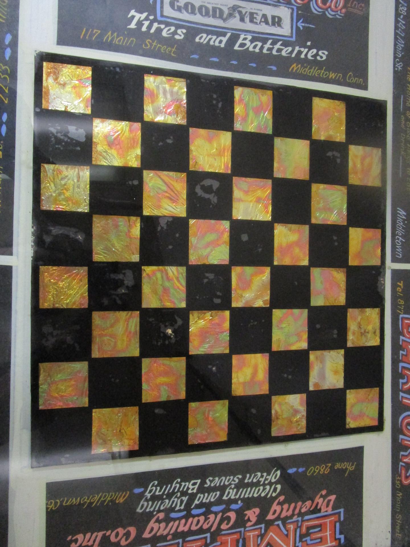 Dieses einzigartige Églomisé-Schachbrett mit Holzrahmen ist von Werbung aus Middletown, Connecticut, aus den 1920er Jahren umgeben. 
Églomisé