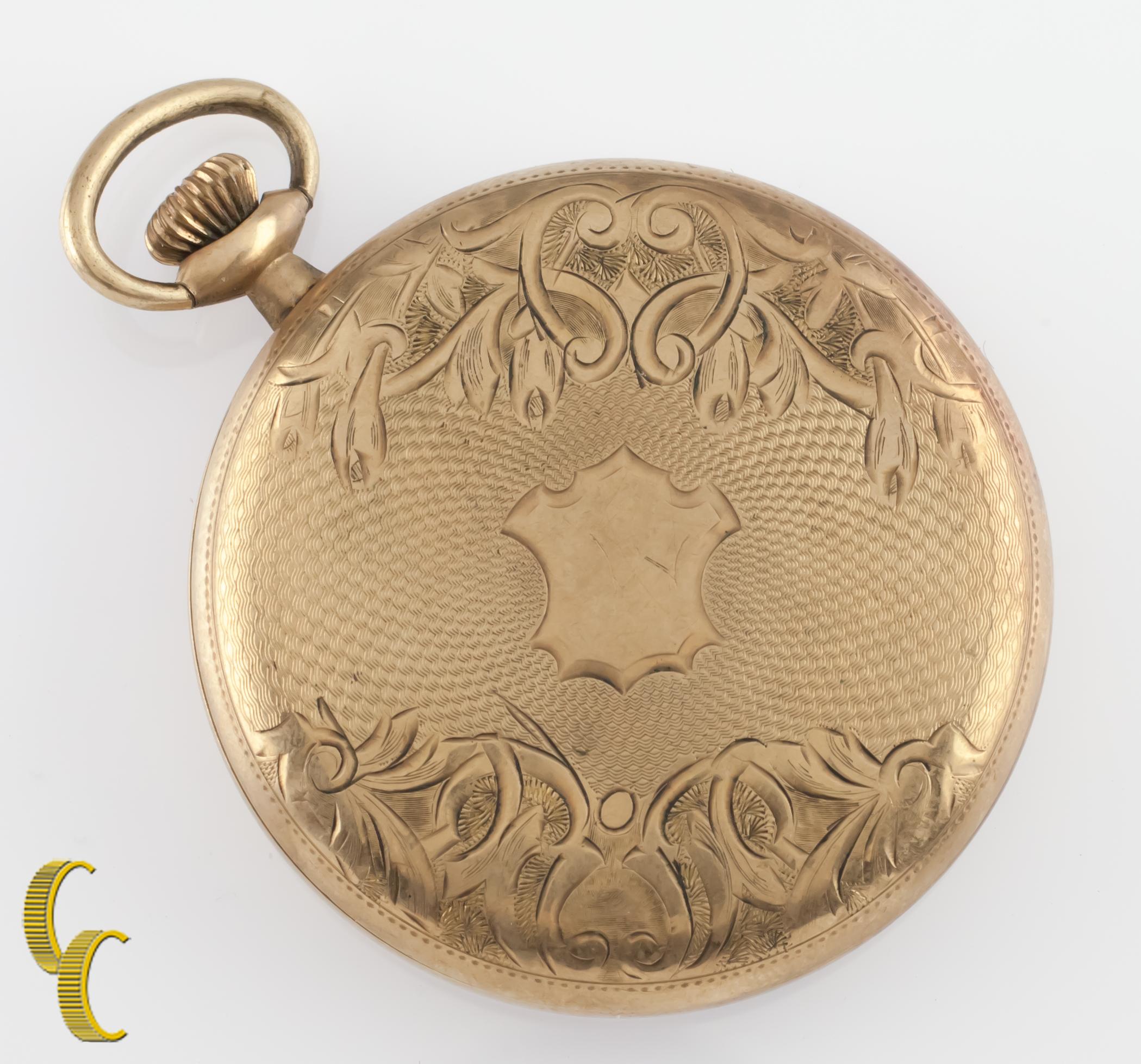 Precioso reloj de bolsillo antiguo Elgin con esfera blanca.
Agujas azules y esfera dedicada a los segundos.
Caja de oro con un intrincado diseño grabado a mano.
Números y marcadores negros.
Caso número de serie 2415652.
Movimiento Elgin de 7 rubíes