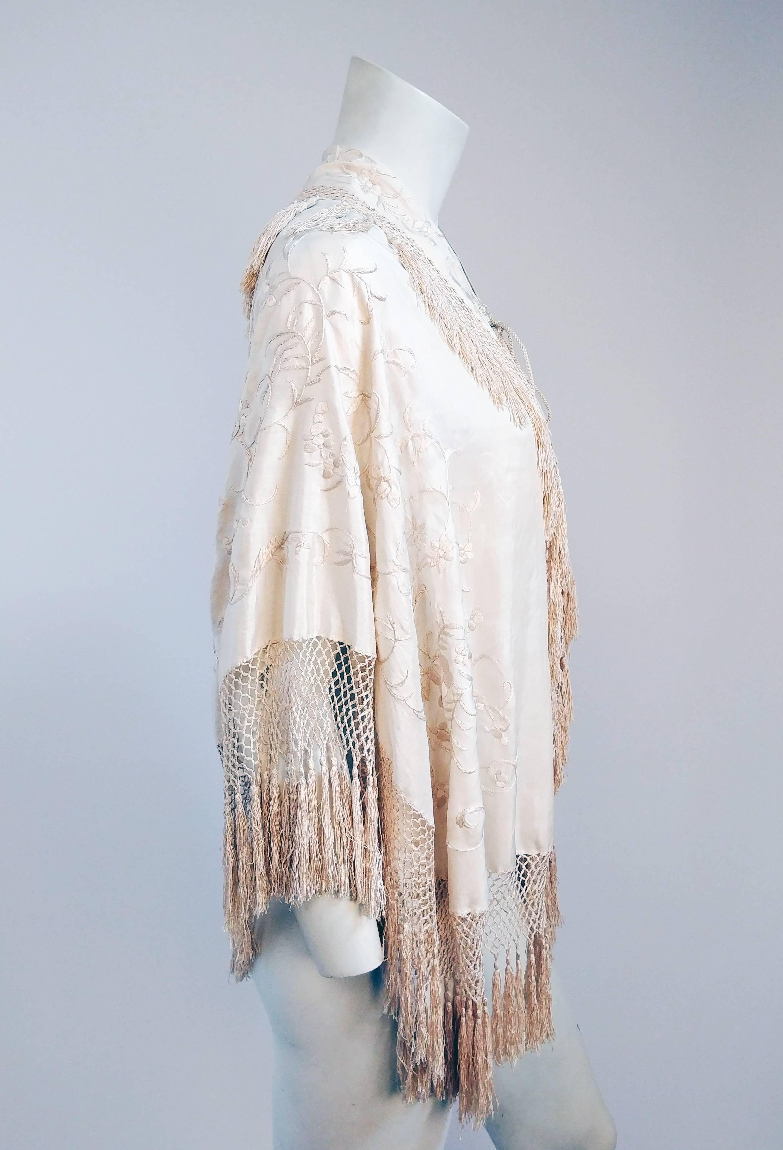 1920s Embroidered Fringe Capelet. Fringed Capelet made from a piano shawl with tasseled cords. Beautiful back applique with knot details. Front cords tie to close. 