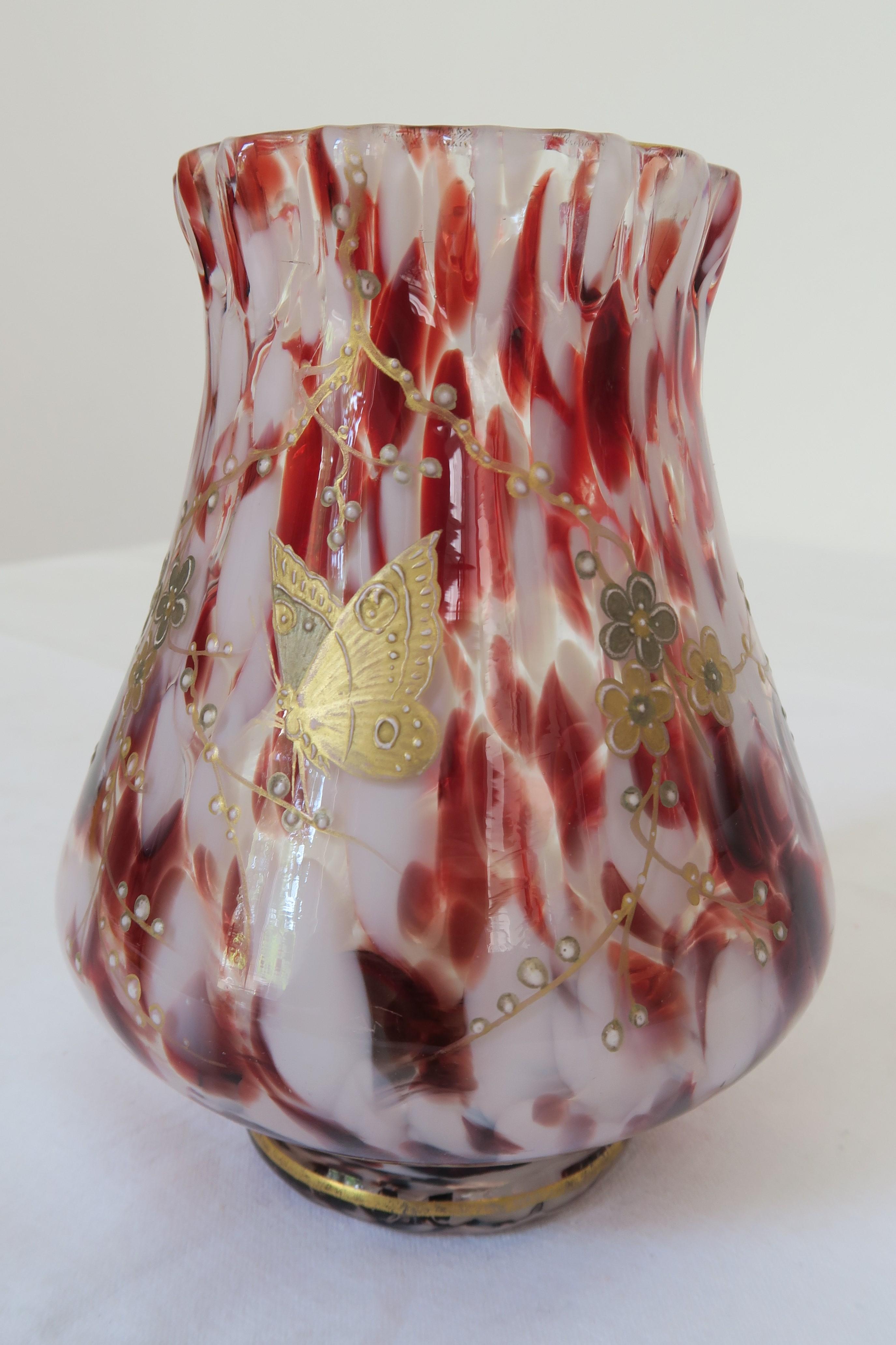 For sale is a pretty little glass vase with red and white specks and gold- and silver colour applications. The design can be attributed to French glass and ceramic Artisan Émile Gallé. The vase is decorated with endearing mutterfly and cherry