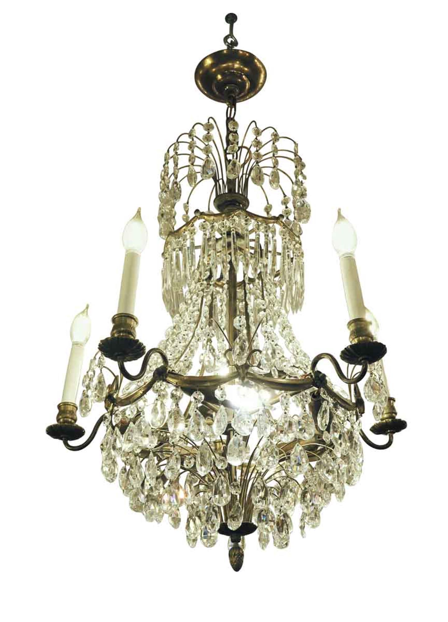 1920s Empire style crystal basket chandelier with a five arm brass frame and five lights inside the ring, pointing sideways. There are 10 lights total. This can be seen at our 2420 Broadway location on the upper west side in Manhattan.