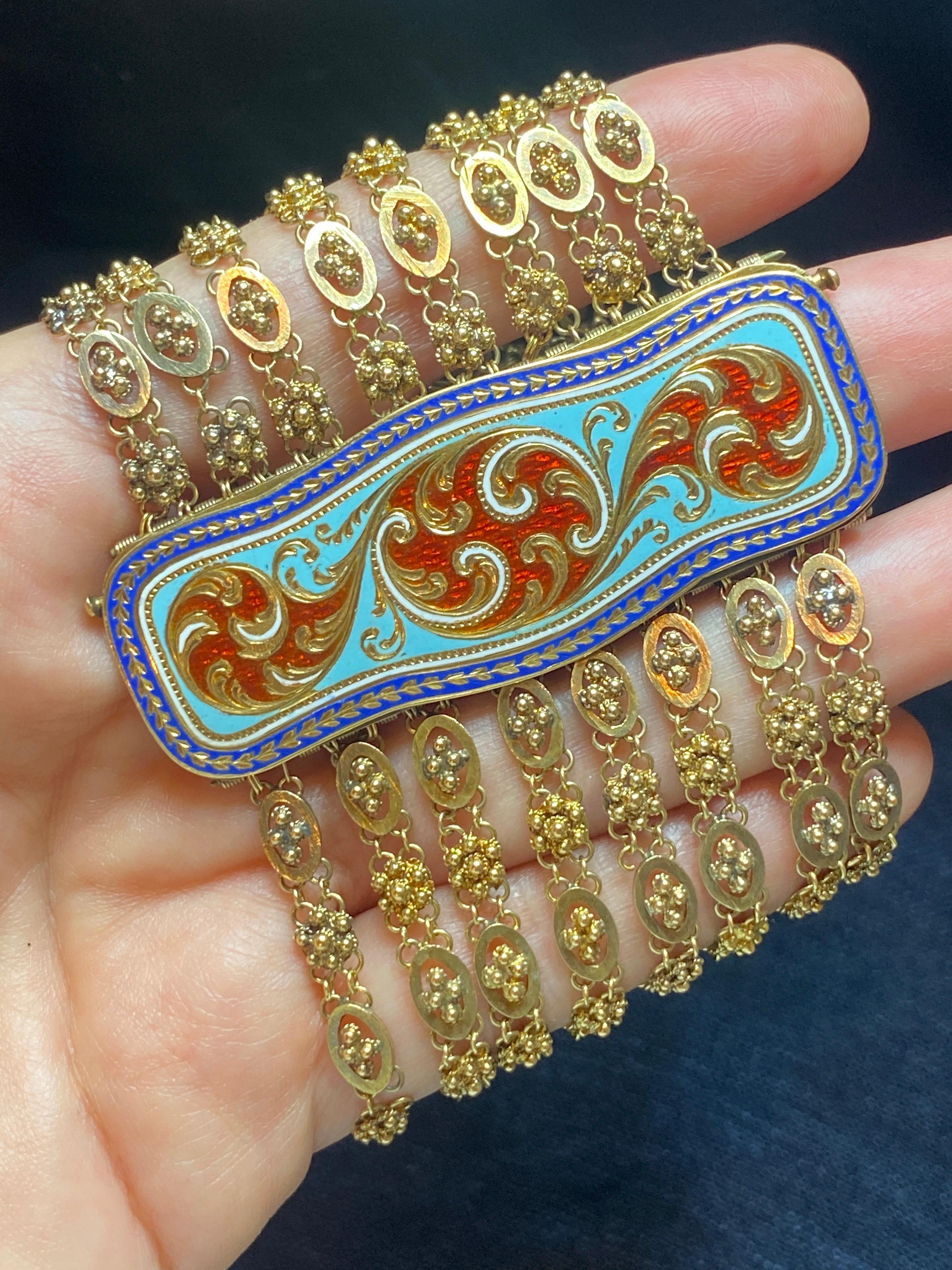 This unique 1920s English 18 carat gold bracelet consists of 8 delicate filigree chains. The buckle is a flawless example of engraved enamel. Beautifully made, it is a striking piece and very comfortable to wear.