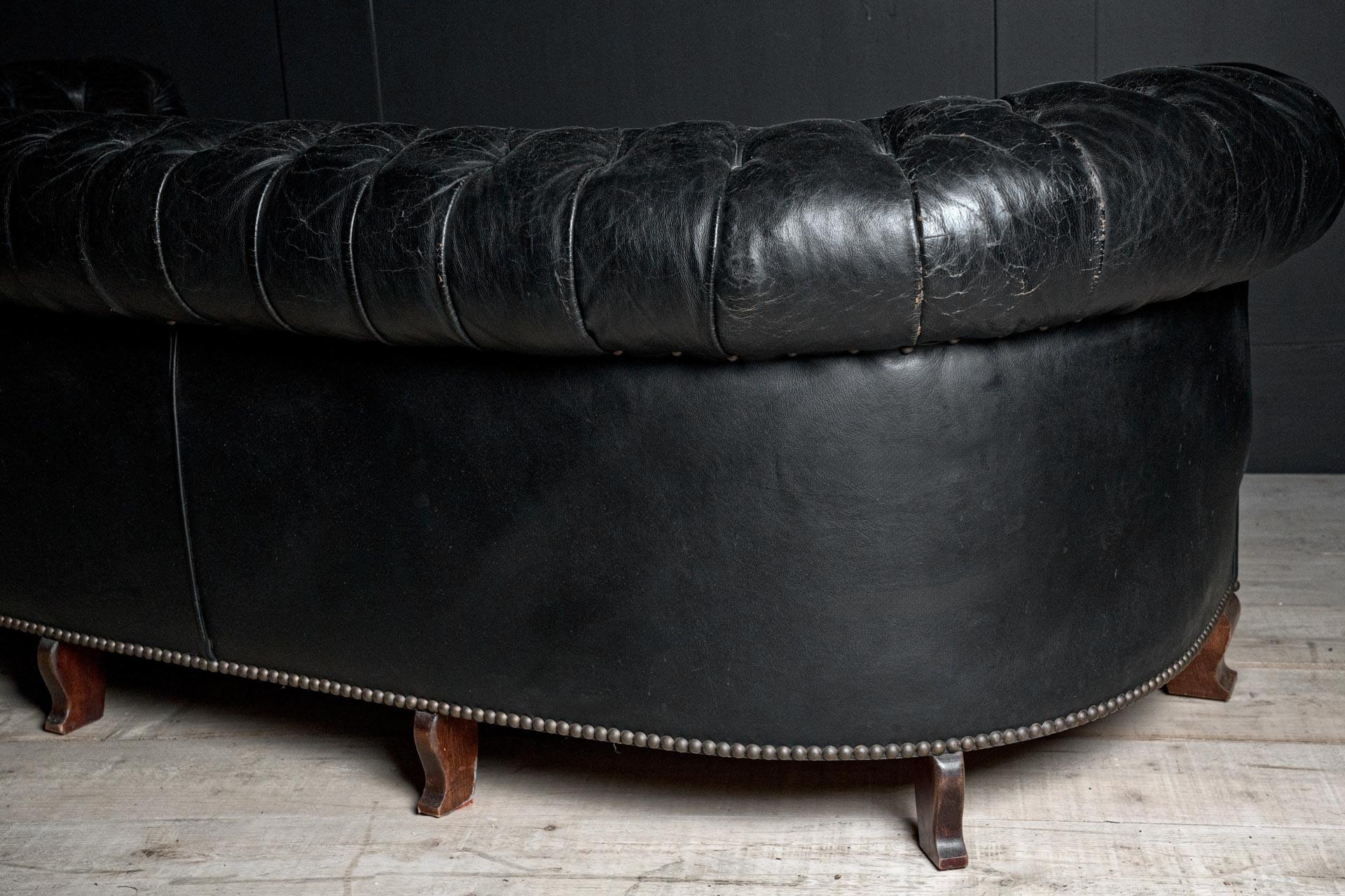 Esempio estremamente raro e distinto del design britannico dei primi del Novecento, questo divano Chesterfield smerlato e curvo del 1920 circa incarna la raffinatezza e il fascino del periodo tra le due guerre. Questo pezzo in particolare è una