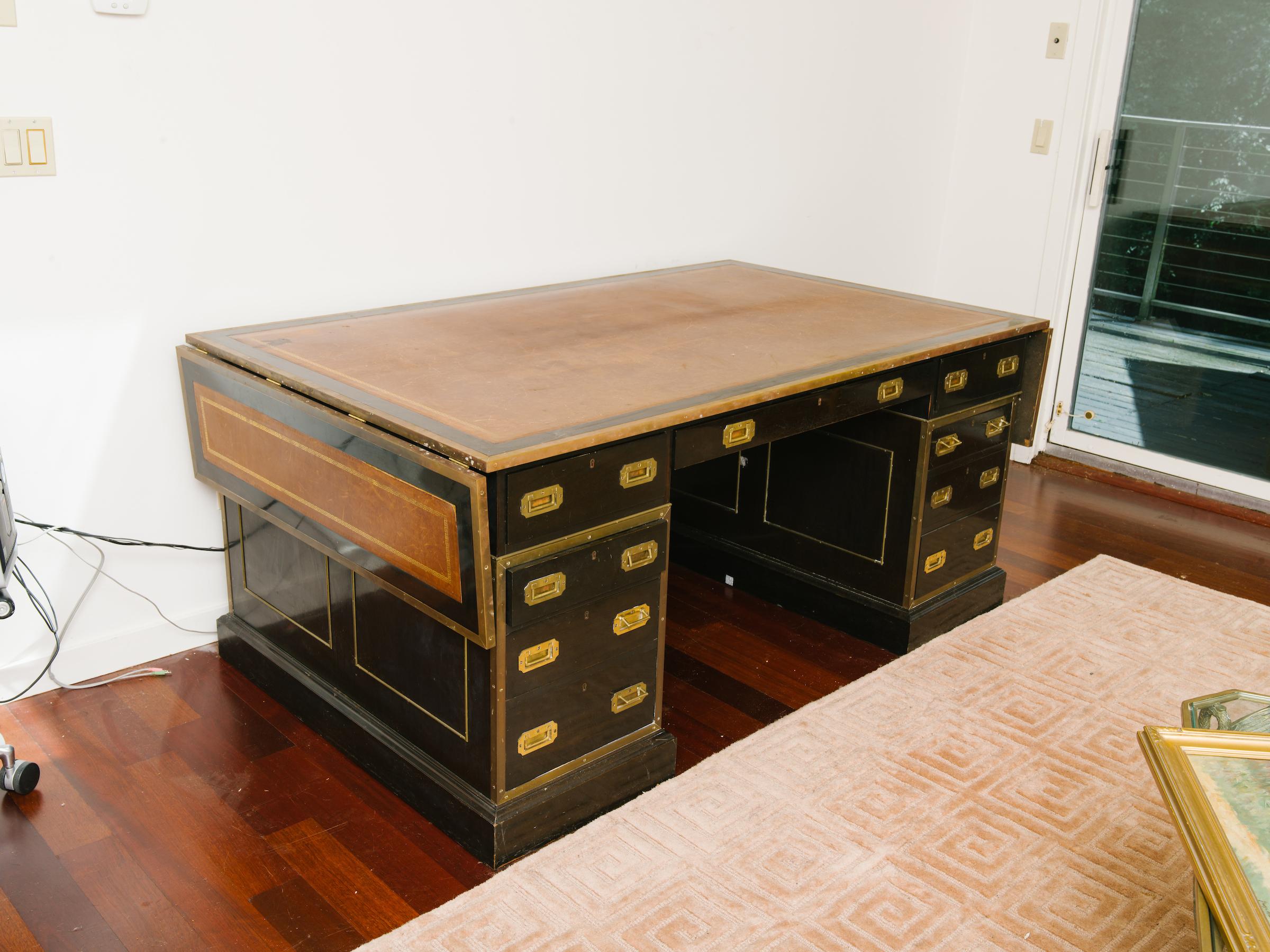 1920s English leather top partners desk with side extensions. Double-sided, drawers on both sides. Once owned by Mariah Carrey and Tommy Mottola when they lived in Bedford, NY. 
When the side extensions are up, the total width is 94 inches.
