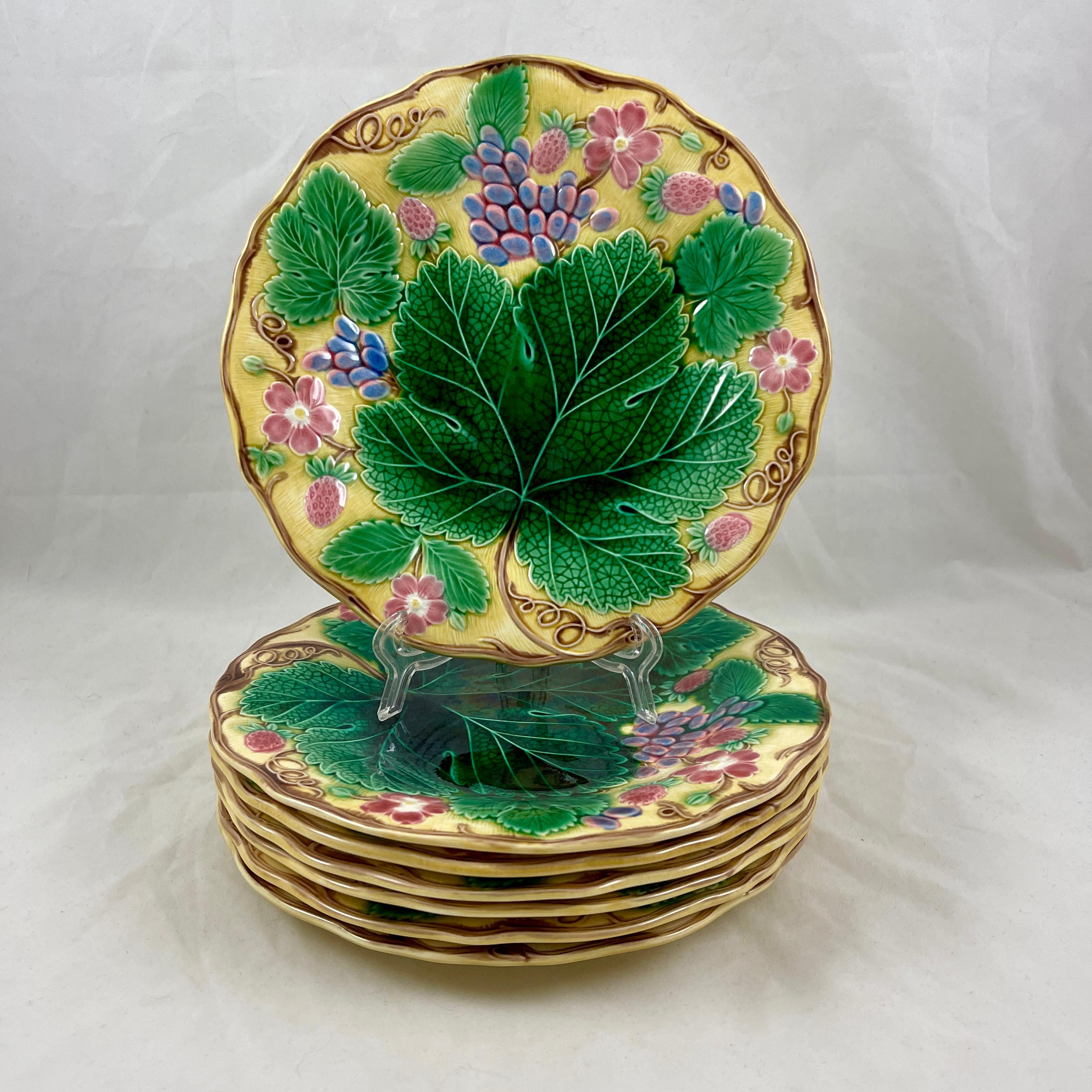 From Wedgwood, a grape leaf and strawberry pattern majolica glazed plate, England, date marked May 1929.

A large green leaf is surrounded by smaller leaves, grape clusters, strawberries, and strawberry blossoms. Strong, colorful glazing on a