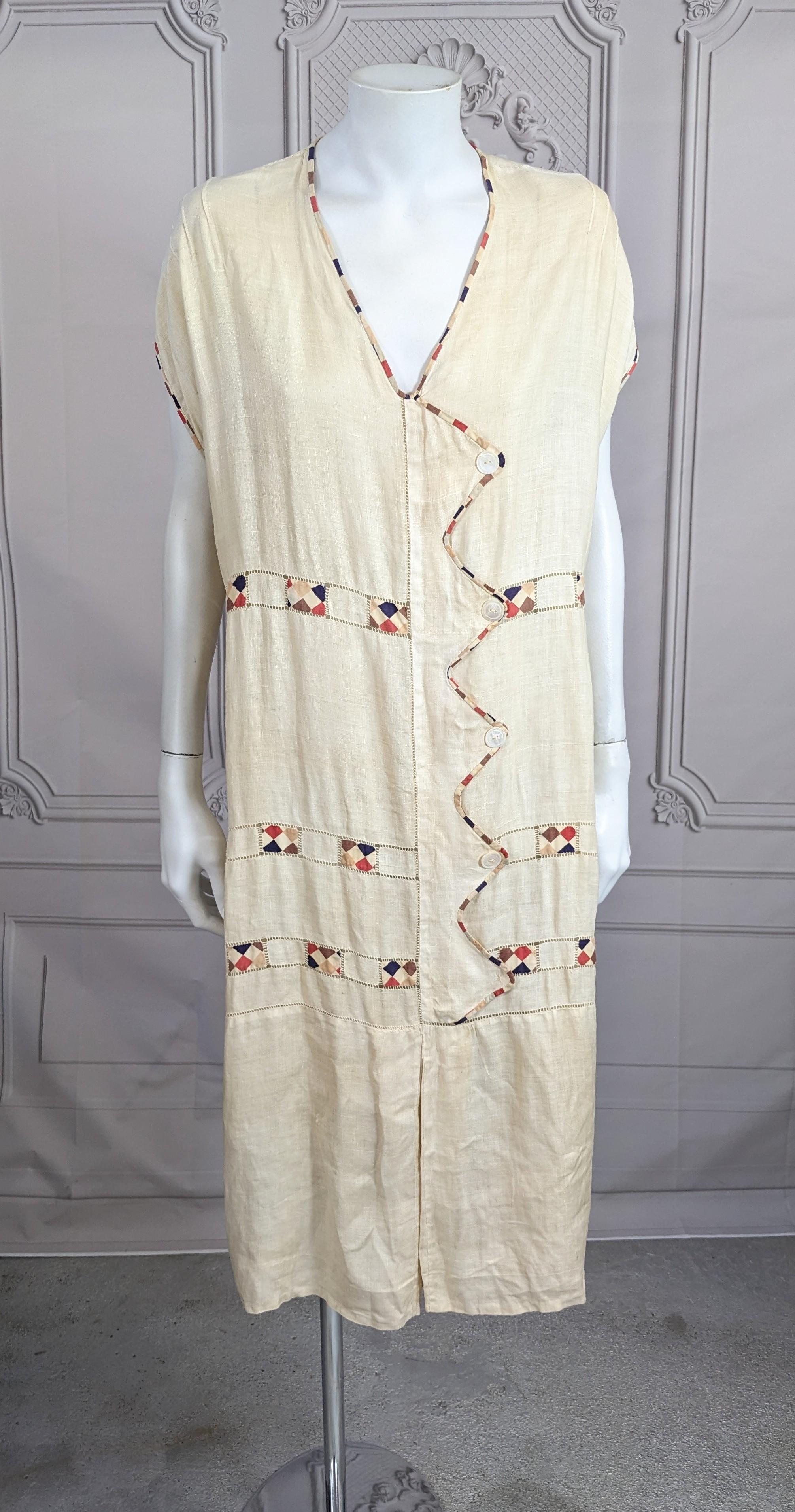 Charming 1920's European Linen Day Dress from the 1920's. Simple straight shape with printed bias cotton tape and openwork detailing on edges. Mother of pearl button accents. High Art Deco styling inspiration. Easy tubular fit with small inverted