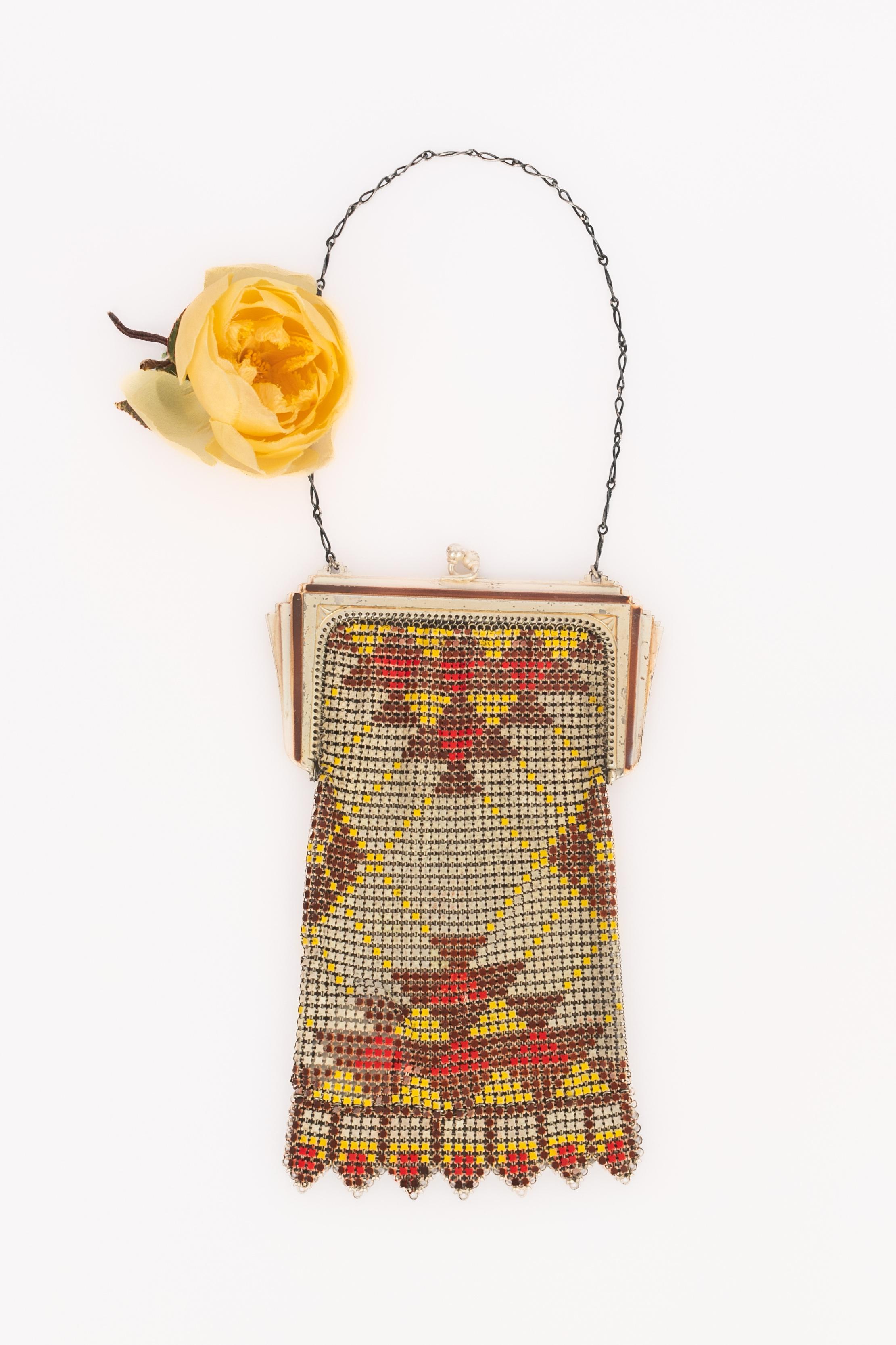 UNKNOWN - Silvery metal minaudiere / evening bag from the 1920s with geometrical pattern made of brown, red, yellow, and gray enameled squared bendable mesh.

Condition:
Good condition

Dimensions:
Height: 17 cm - Width: 11 cm - Handle: 30