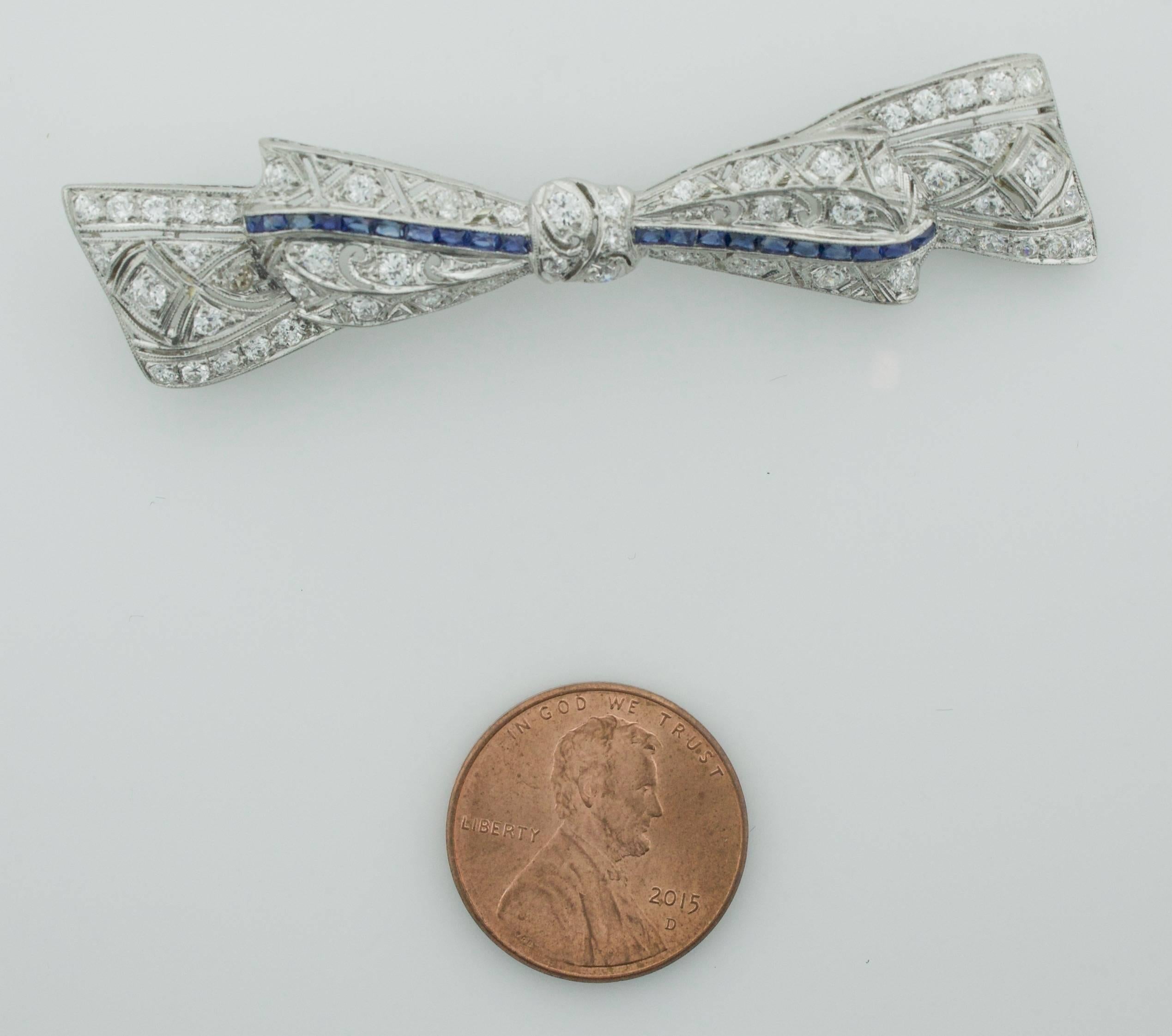 1920's Exquisite Platin Diamant und Saphir Schleife Brosche 
Vierundfünfzig alte europäische Diamanten mit einem Gewicht von 2,00 Karat (ungefähr)
Zwanzig kalibrierte Saphire im französischen Schliff mit einem Gewicht von etwa 0,70 Karat

Jede Farbe