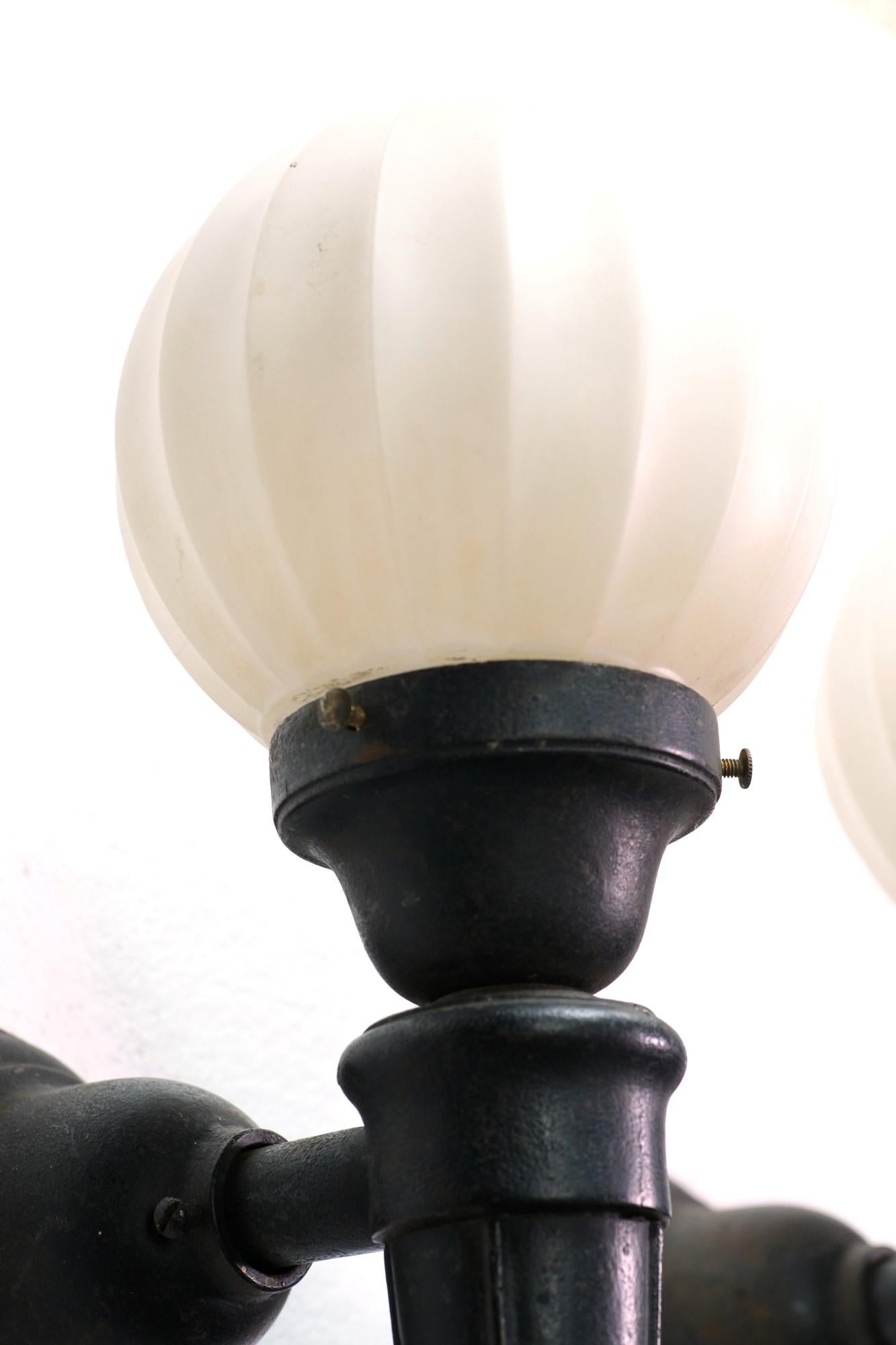 1920s Exterior Black Cast Iron Sconces with Round Fluted & Frosted Glass Globes  In Good Condition In New York, NY