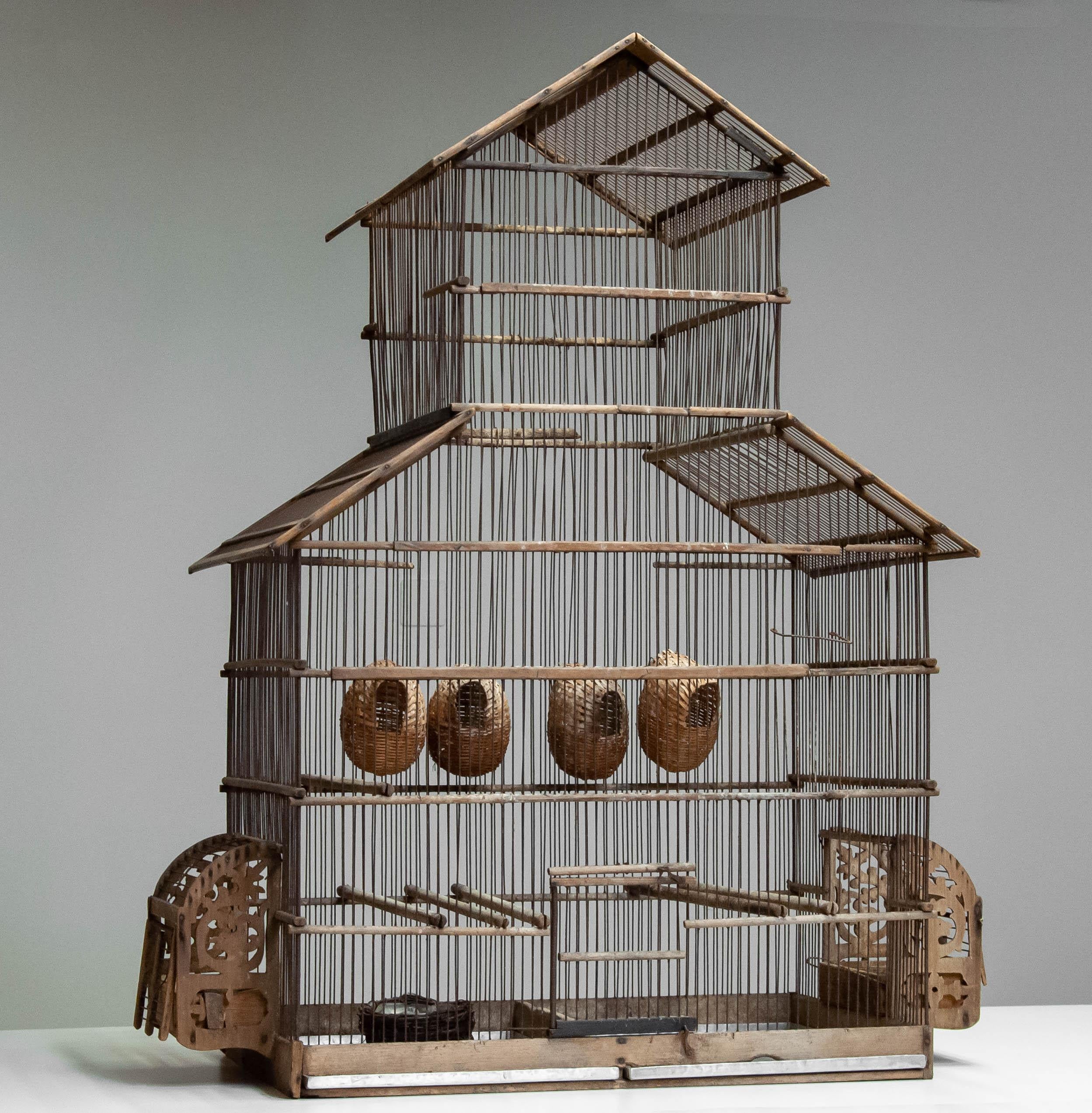 Very impressive and still functional wooden bird cage from the 1920's.
The rusty and worn vintage look makes this bird cage a fantastic eye-catcher into your interior.
Two zinc plates on the bottom four birdhouses and two seed trays are