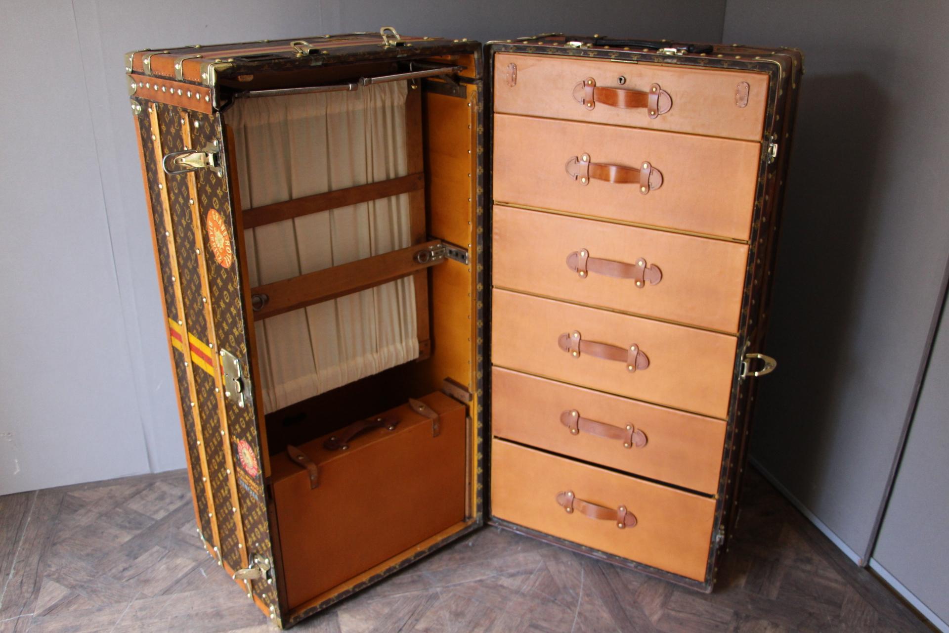 This impressive Louis Vuitton wardrobe features stenciled monogram canvas, lozine trims, brass LV stamped locks and studs as well as its lift top. It has got a beautiful warm patina.
Customized painted yellow and red strips, as well as many