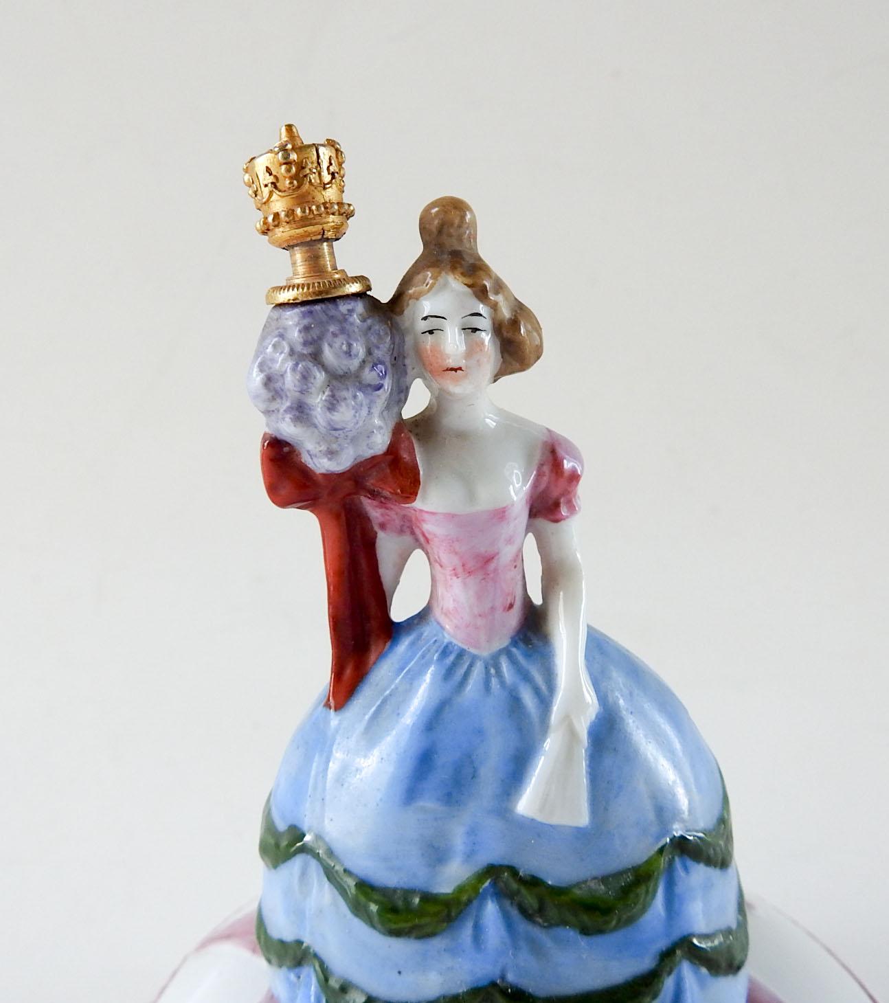 Circa 1920's porcelain trinket box combined with perfume bottle.  Marked  Sitzendorf Germany on bottom.  Perfume stopper is brass crown, figure is woman in 18th century costume.  Very good condition.
