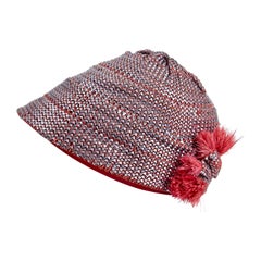Sombrero cloche estilo «flapper» de los años 20, con tejido de rafia metalizada y adorno de plumas