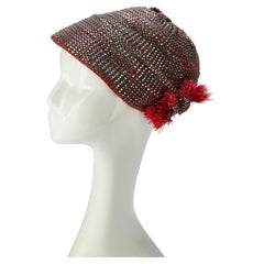 Sombrero cloche estilo «flapper» de los años 20, con tejido de rafia metalizada y adorno de plumas