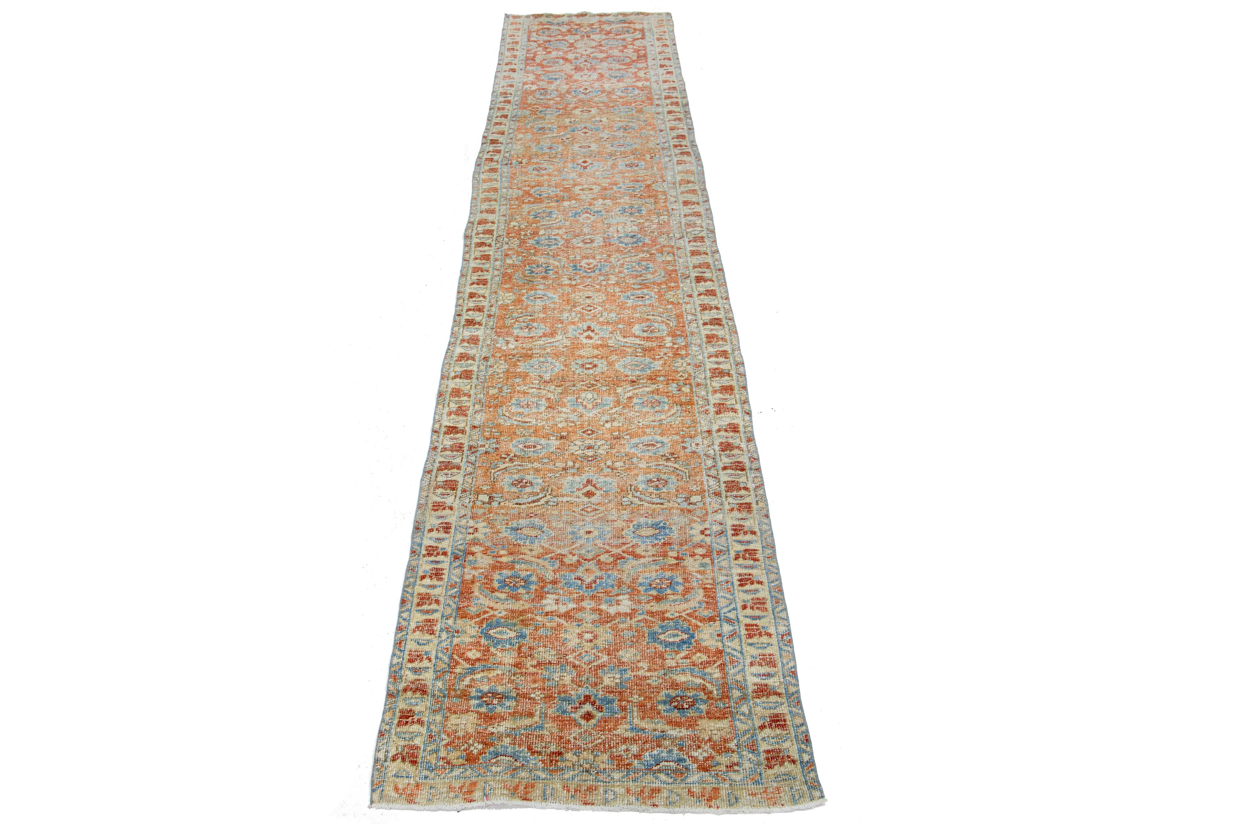 Beautiful 20th-century Heriz hand-knotted wool runner with a rust-colored field. This Piece has blue accents in a gorgeous tribal design.

This rug measures 3' x 14'2
