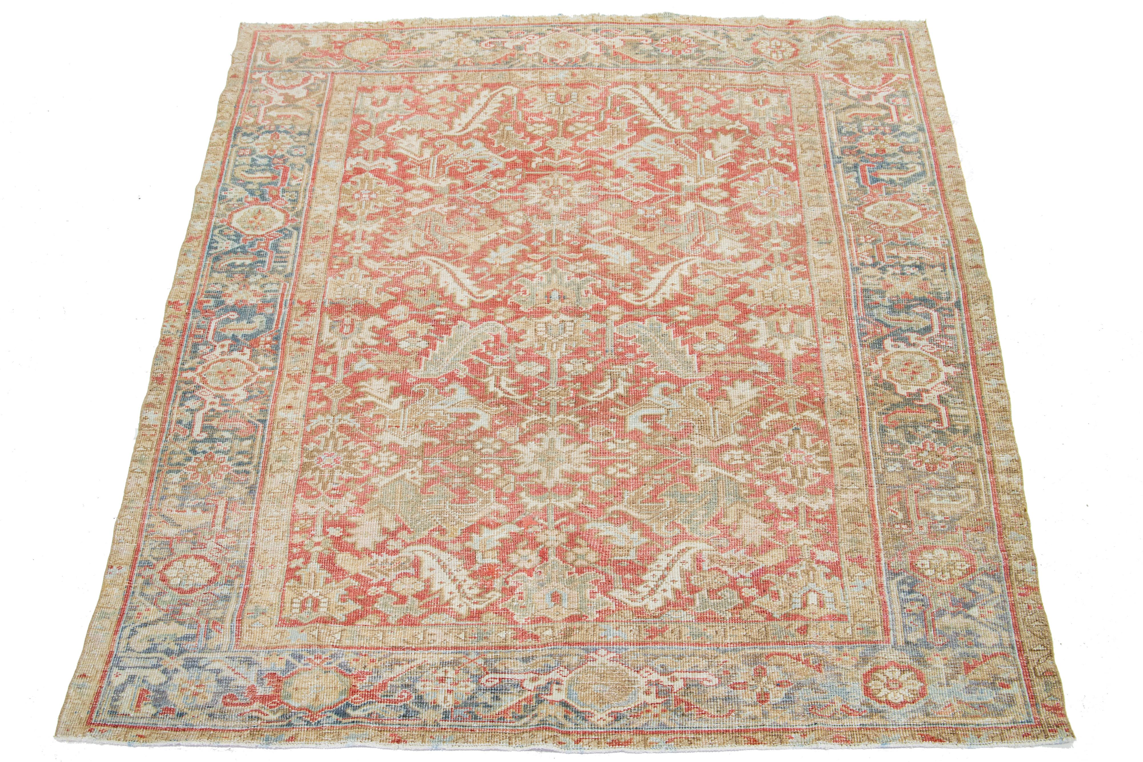 This antique Persian Heriz rug is crafted with hand-knotted wool. The rust-colored field features a captivating allover pattern embellished with shades of blue, beige, and brown.

This rug measures 7'1