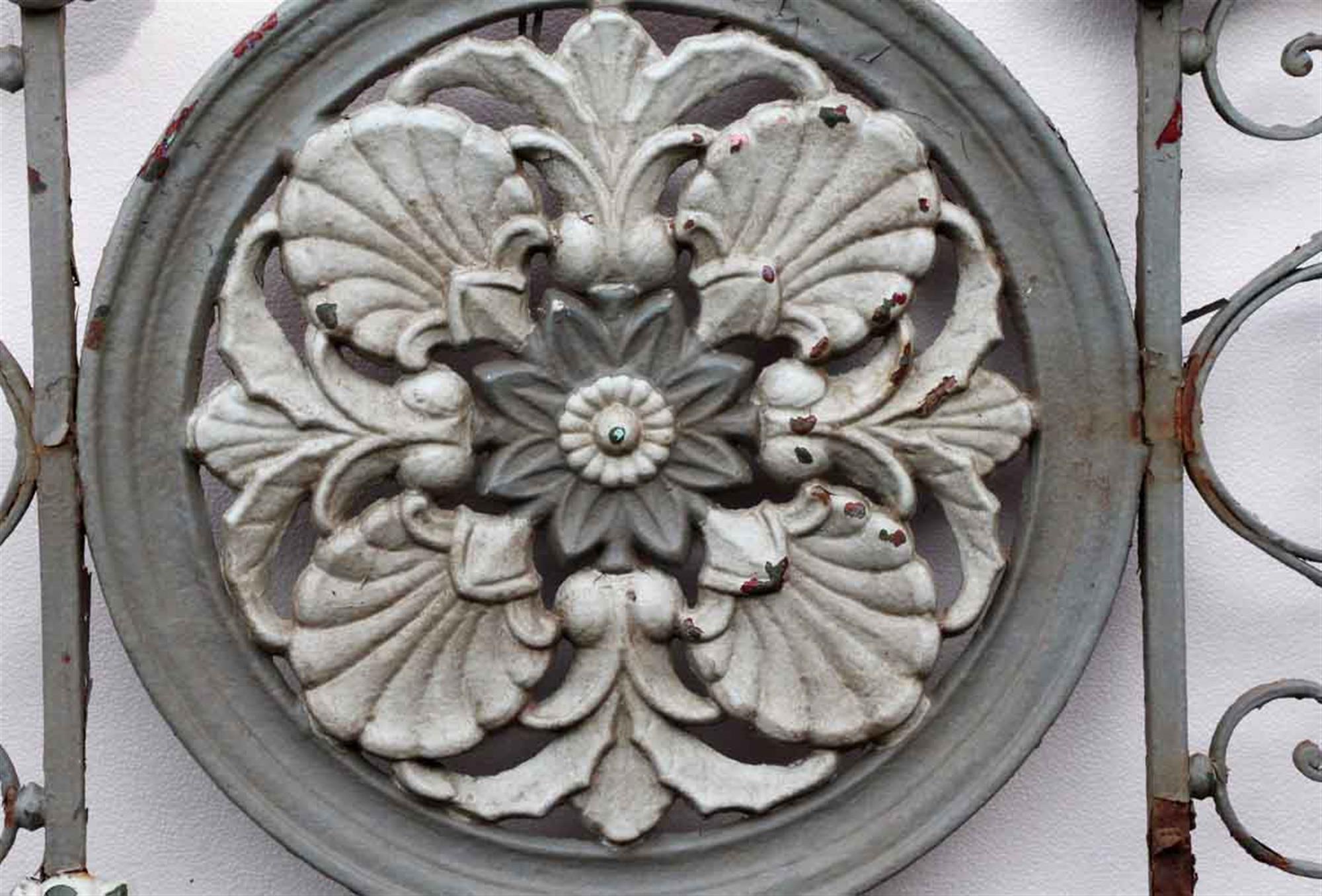 Gray and white iron balcony with floral details. Shows wear from age and use. Flower missing on lower right corner. Other minor loses. This can be seen at our 400 Gilligan St location in Scranton, PA.