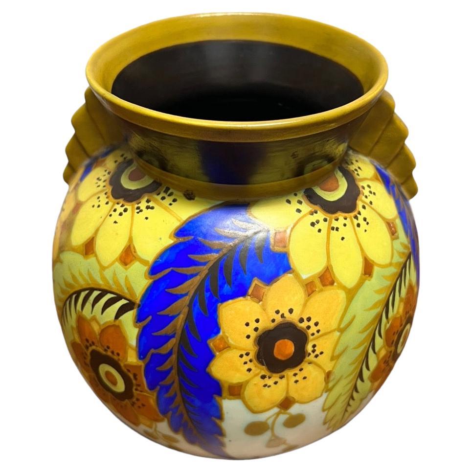 Introducing a truly exquisite floral vase from the 1920s, a magnificent showcase of the artistic genius of Charles Catteau (1880-1966). Crafted from earthenware, this vase stands as a testament to Catteau's exceptional mastery of form and