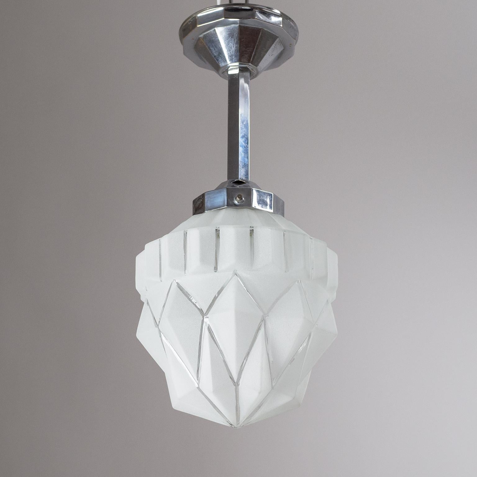 Classic geometric French Art Deco pendant from the 1920s. The hardware is chromed brass with a hexagonal stem and 12-sided canopy and socket cover. Suspended from this is a multi-facetted and tiered frosted glass diffuser. Very nice original