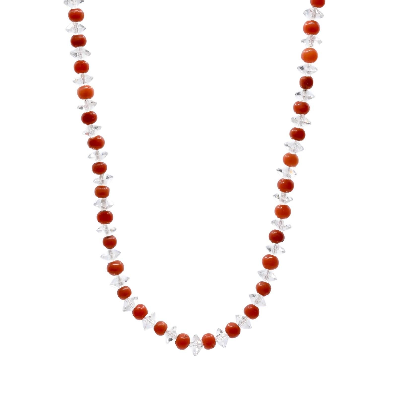 An Art Deco period French hallmarked fine coral and rock crystal necklace with diamond set clasp in platinum. This necklace is comprised of very fine coral beads interspaced with faceted rock crystal. Set with one European cut and six rose cut