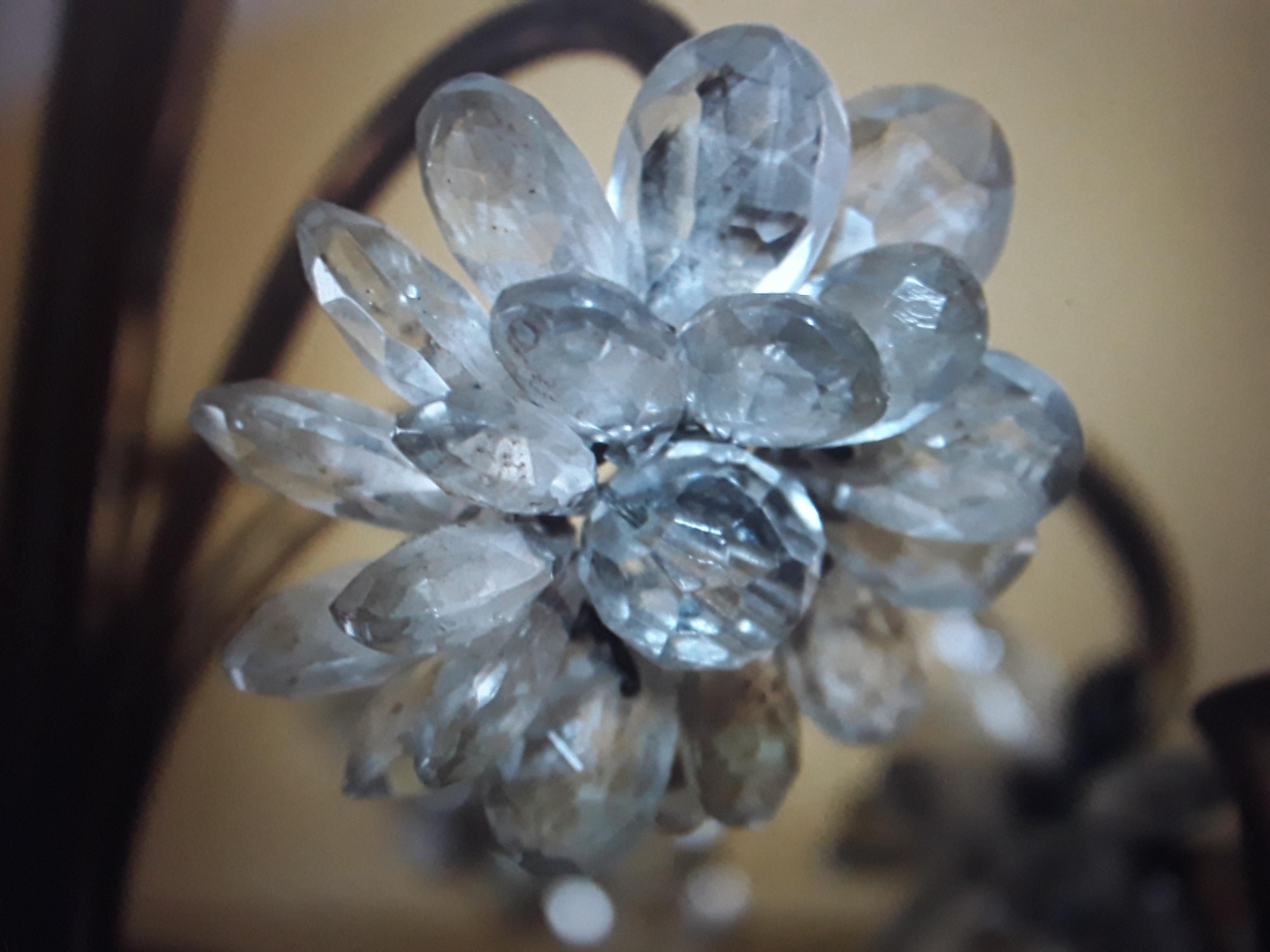 Französischer Art-Déco-Kronleuchter aus patiniertem Eisen und Bergkristall aus den 1920er Jahren. Die Schmiedearbeiten sind erstaunlich. Viele voll blühende Kristallblumen. Dieser Kronleuchter ist eine echte Schönheit!