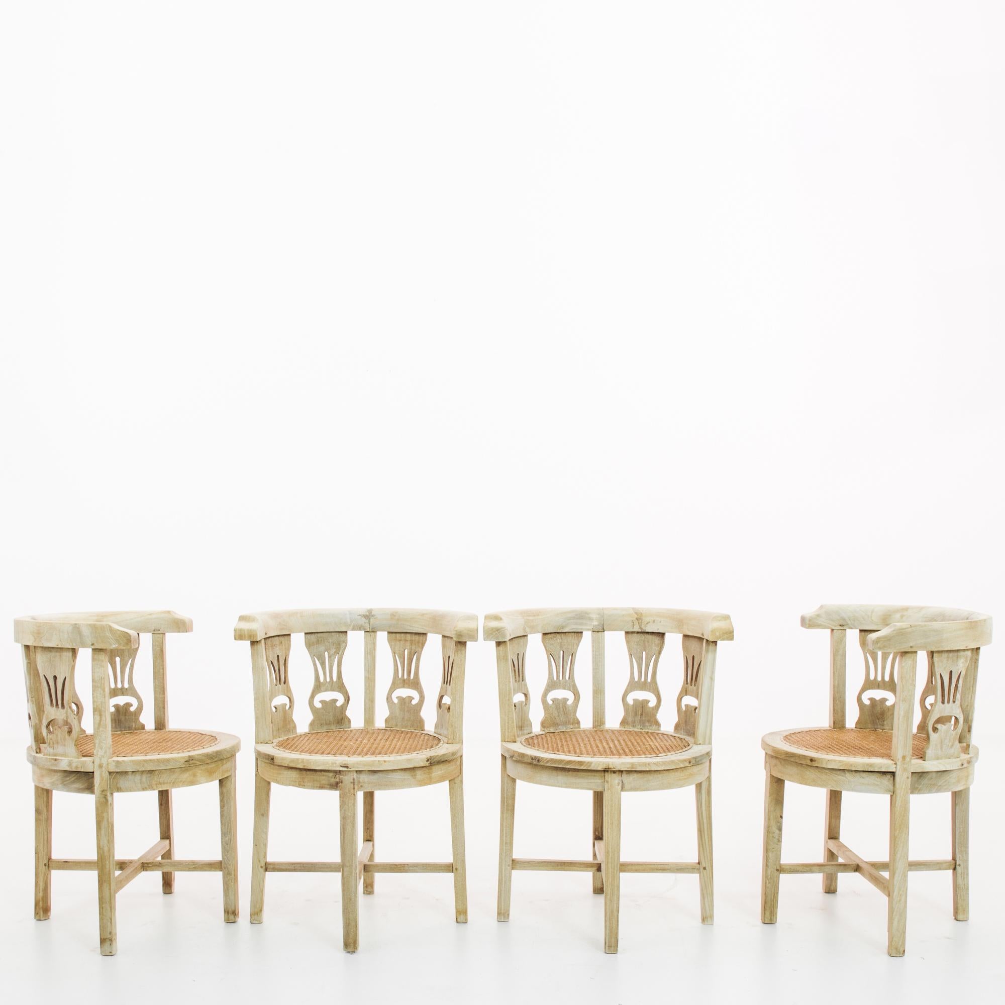 This set of four wooden chairs was made in France, circa 1920. They feature circular seats with curved backrests. Contoured splats with decorative cutouts, reveal the backdrop of the Art Deco era--with a decisive geometry and pleasing rhythm. Four