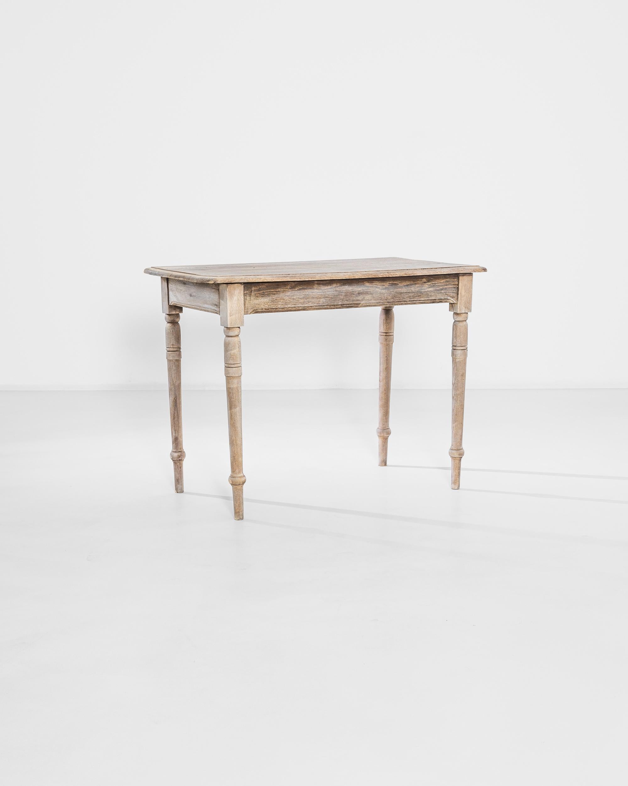 A regal bleached oak table, circa 1920 France. Featuring a hand-planed top, a chiseled apron, and lathed legs, this table displays a restrained and masterful work of craft. Its warm bleached oak makes it easy for this table to both fit in and stand