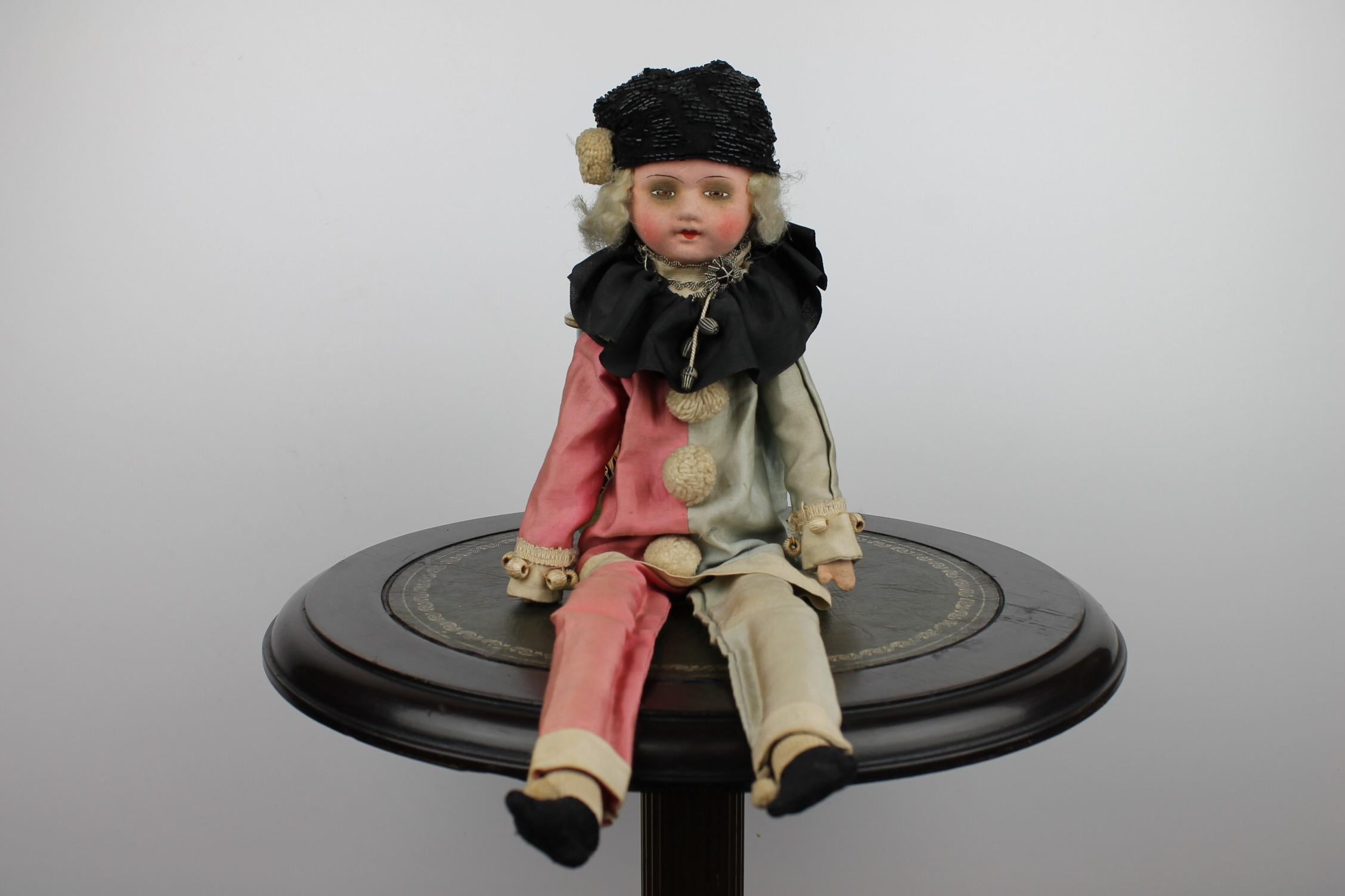 Antique French Boudoir Pierrot - Harlequin doll of the Art Deco Period. 
Expressive early 20th century antique toy doll dressed in original satin and clothes. 
Composition head, fabric body filled with straw, hands and legs.
For the age still in