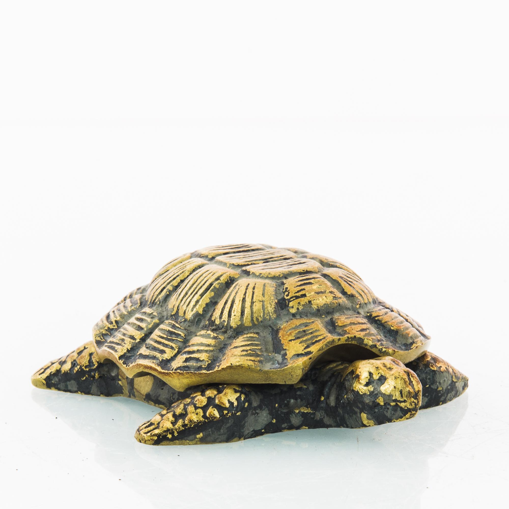 A brass paperweight from 1920s France in the shape of a turtle. Dark indentation contrasts with bright highlights, lending the solid form an energetic quality. Considered a symbol of patience and long life, this turtle makes an appealing vintage