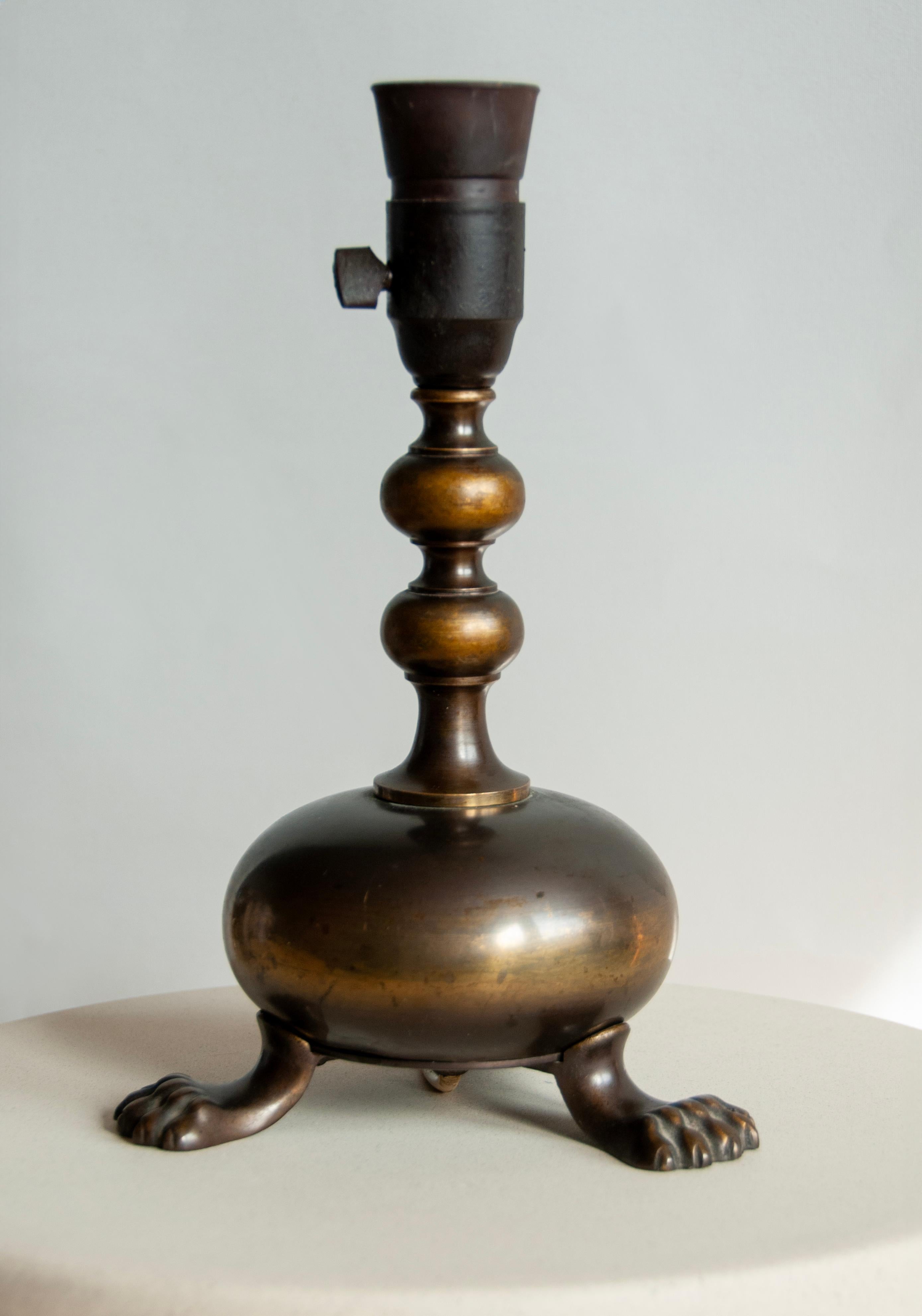 Une charmante lampe de table française avec des pieds de lion distinctifs, mettant en valeur son élégante origine française. Fabriquée dans une couleur bronze intemporelle, cette lampe dégage une allure vintage, ornée d'une usure et d'une patine