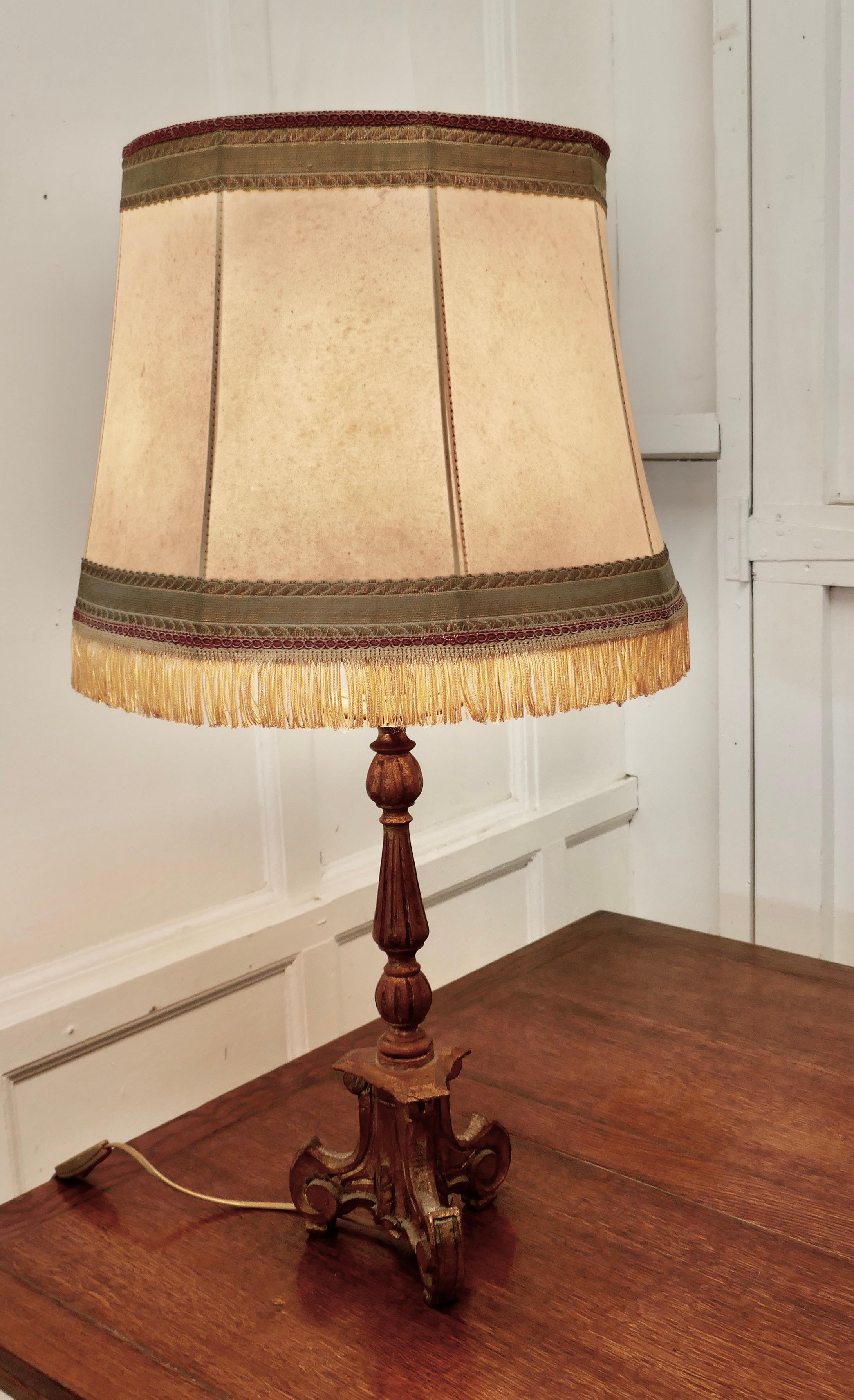1920s French carved gilt lamp, vellum shade

This an attractive gold painted lamp, the lamp has a carved Column which is painted in Gold, the paint has now aged in colour and developed a charming faded finish, the lamp has its original fringed